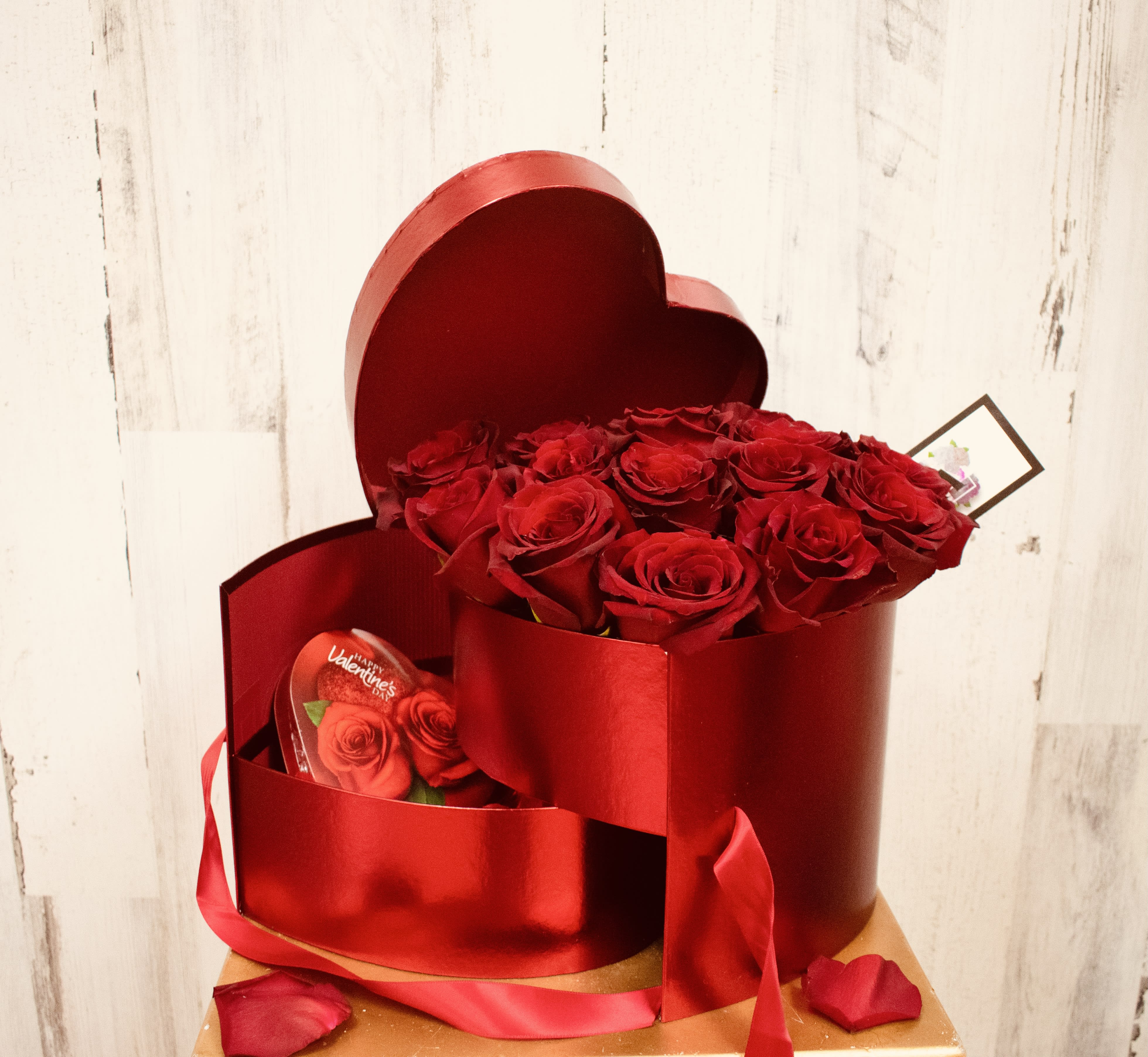 Sweet Temptations - Deep metallic red heart shaped box comes with two compartments. Top compartment has approximately 18 top quality Ecuadorian roses color of choice. The lower compartment is filled with rose petals and a cute heart shaped box of milk chocolate. All wrapped closed with a satin ribbon. 