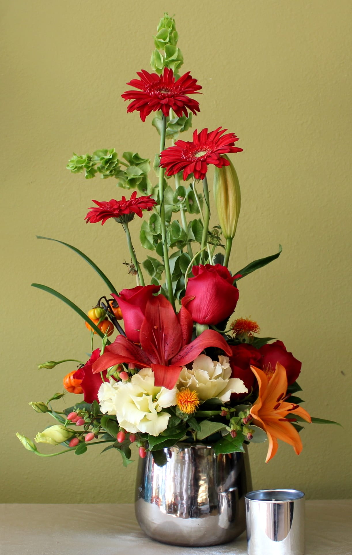 Daisy Dream - red gerbera daisies with red roses and red and orange Asiatic lily's, bells of Ireland and coffee beans 