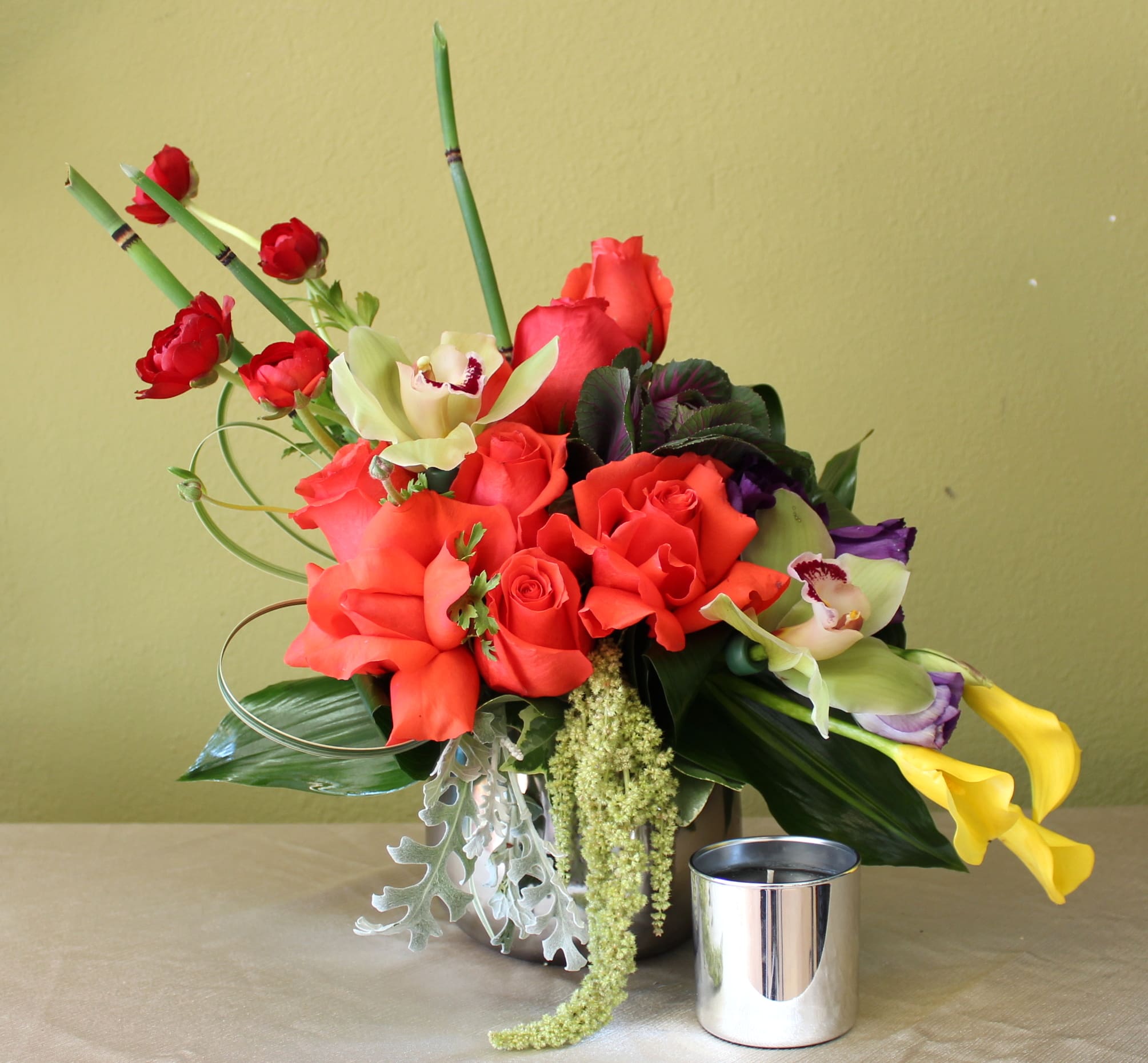 crazy for you  - orange roses, green orchids yellow calla lily's in a silver round vase  