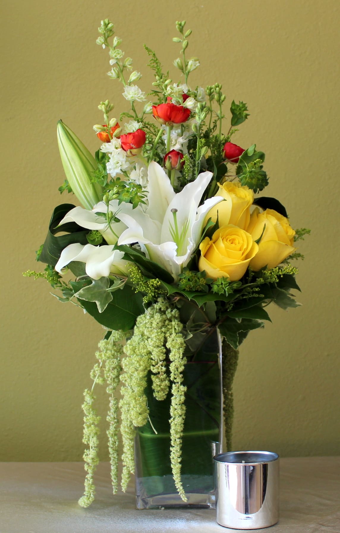 love inspiration  - yello roses, white casa Blanca lily's, white larkspur and orange ranunculus  in clear glass tall vase 