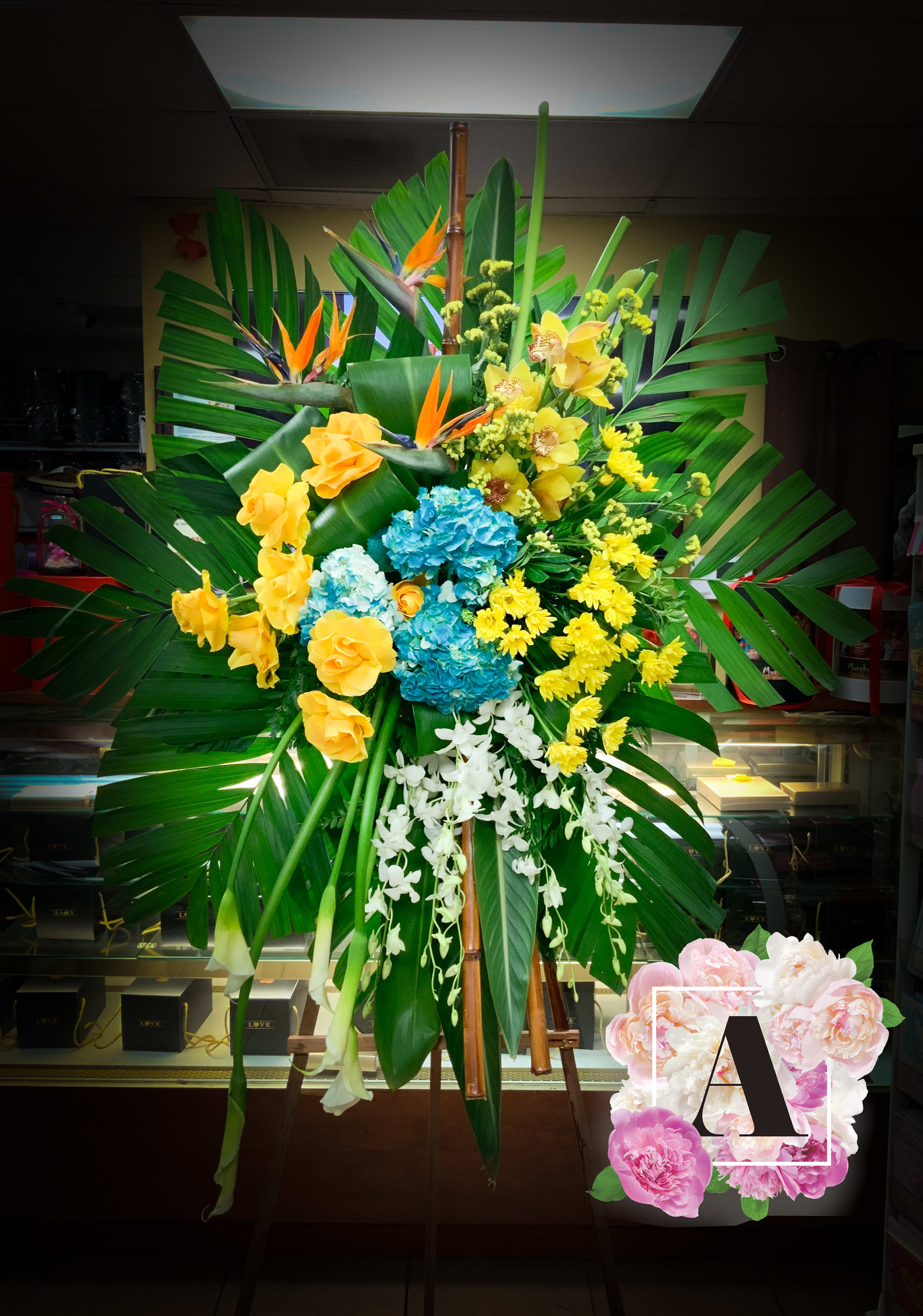 Blue Tropical Sympathy - Includes Bamboo, birds of paradise, white dendrobium orchids and bamboo. Please let us know of any color change preference arran7will come approximately as shown. 