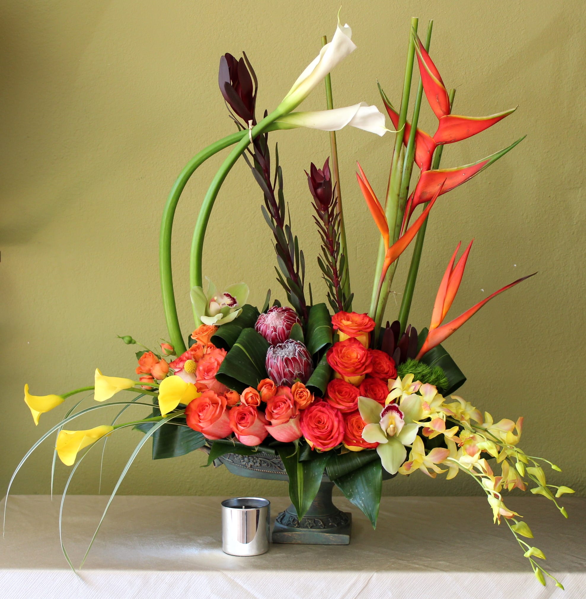 tropical garden  - white calla lily's, proteas, mini yellow calla lily's, cymbidium orchids and dendro yellow orchids, lily grass , hanging in a ceramic vase 