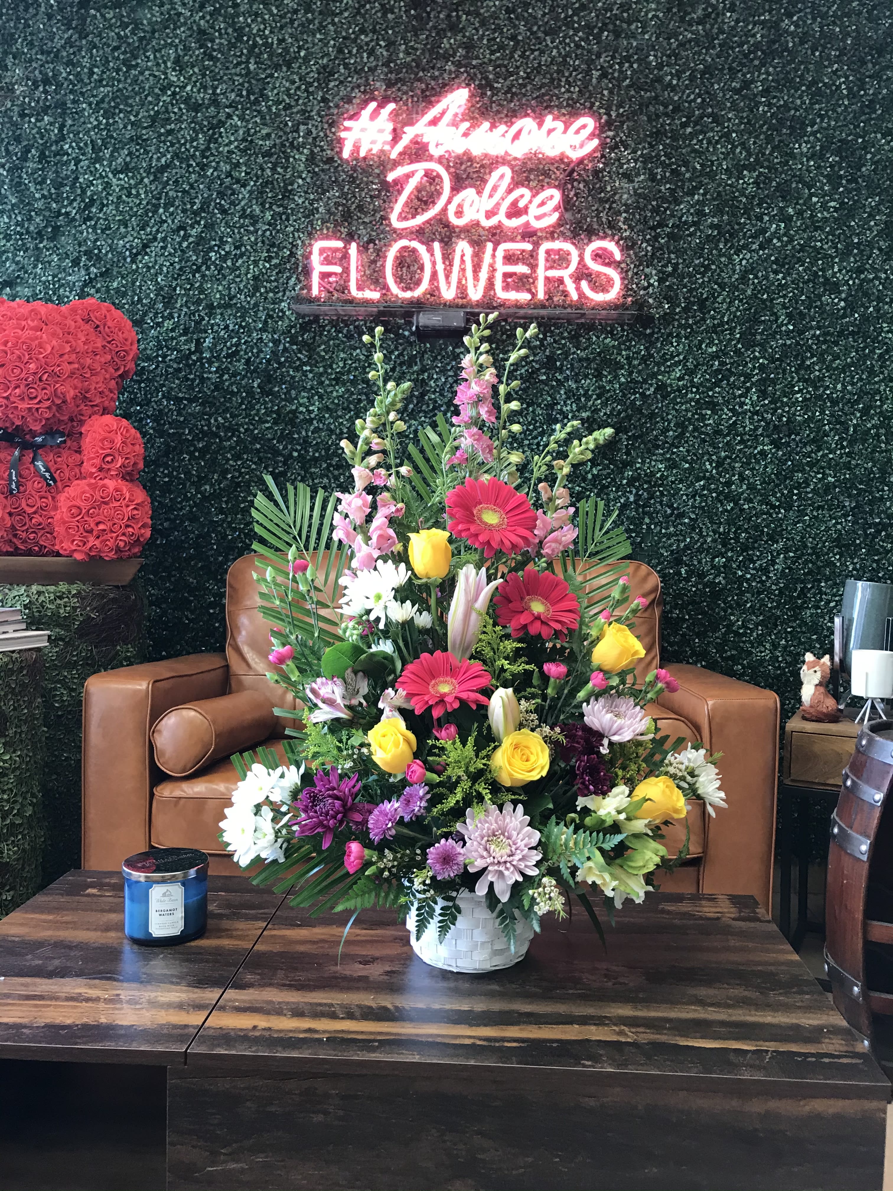Mixed flower arrangement in a white basket on a table