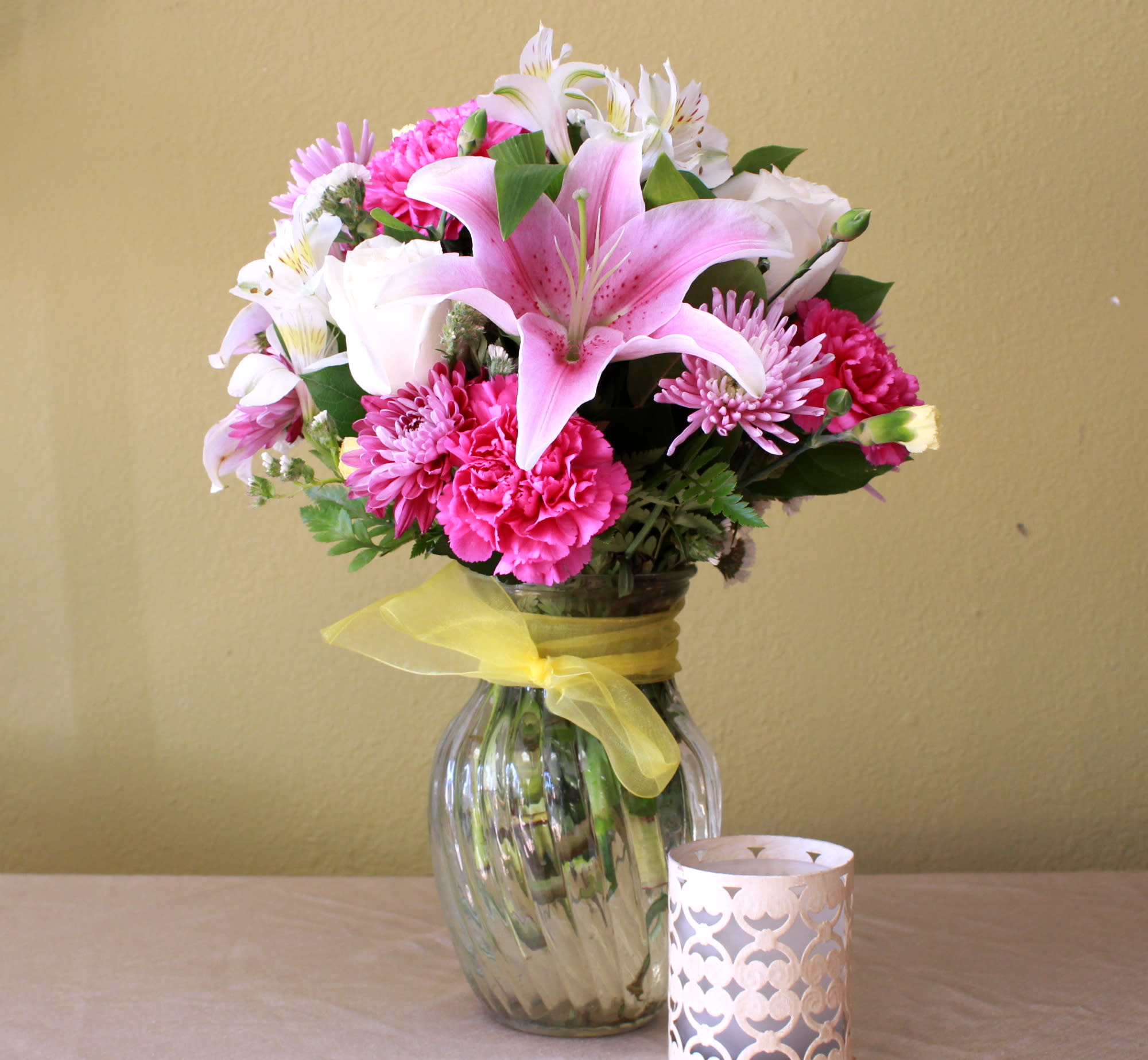 lily desing bouquet - Stargazer lily, hot pink carnations white roses, white astromerias and lavender mums in a clear glass vase 