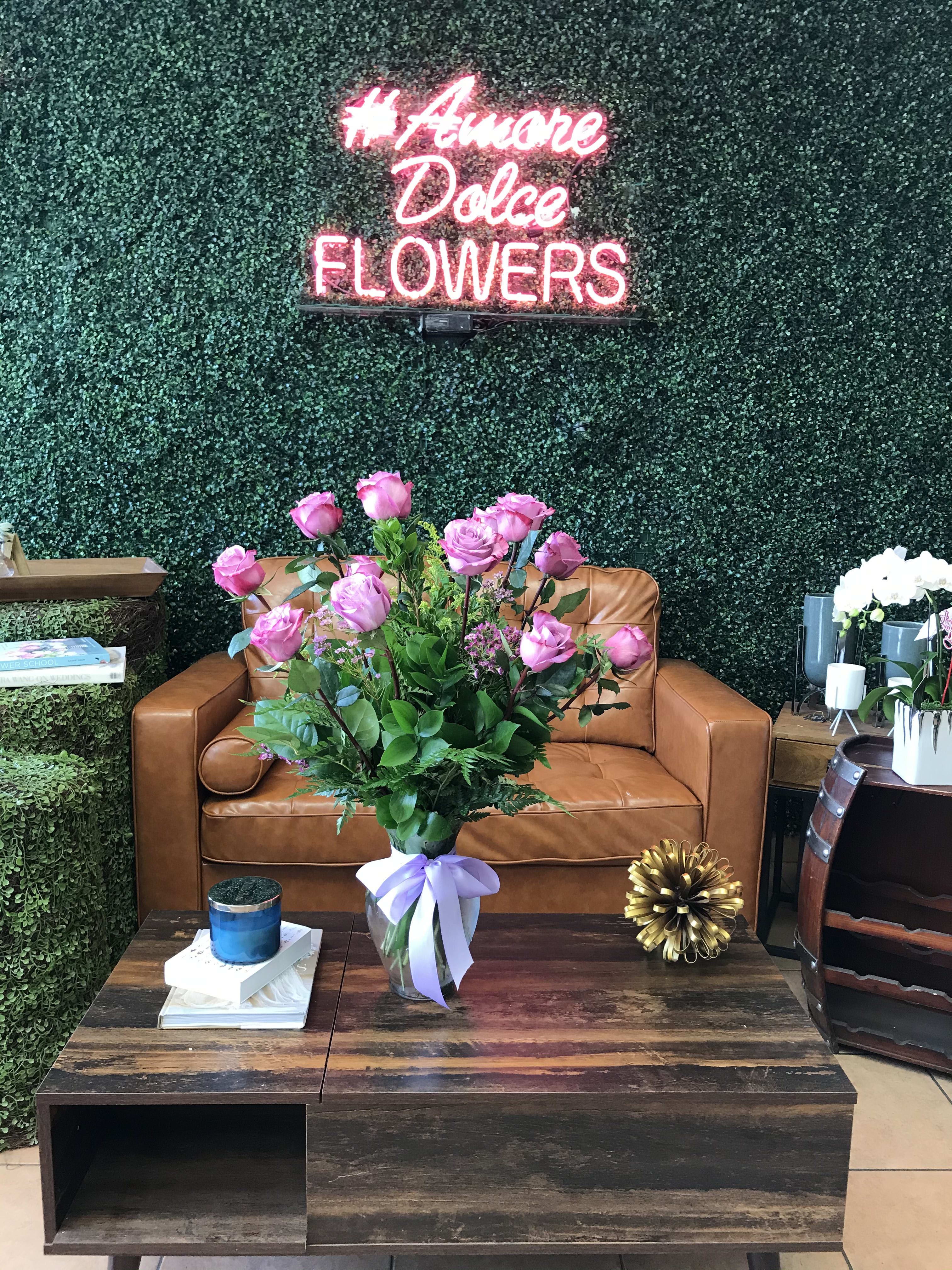 Designers Mix Dozen - Beautiful Ecuadorian long stem roses arranged tall in a glass vase with filler flowers, including mini wax flowers and solidago. Color of the roses will depend on availability. Designer will choose one of our available colors of long stem roses.                           