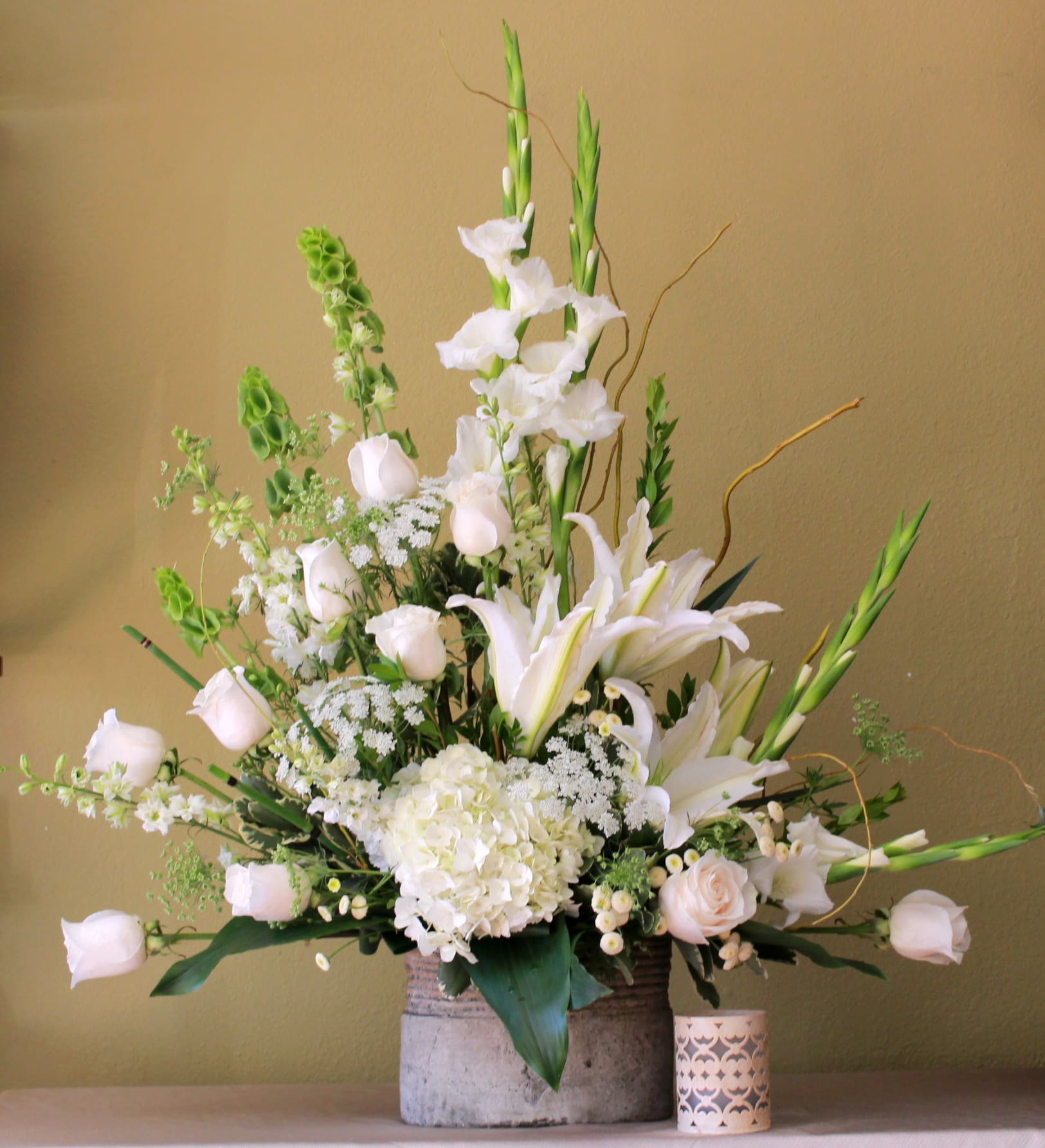 simple thougths  - all with sympathy arrangement,.Gladiolus, Roses, Casa Blanca lily's, queen Ann lace, bells of Ireland, hydrangeas and  curly willow on a ceramic container.