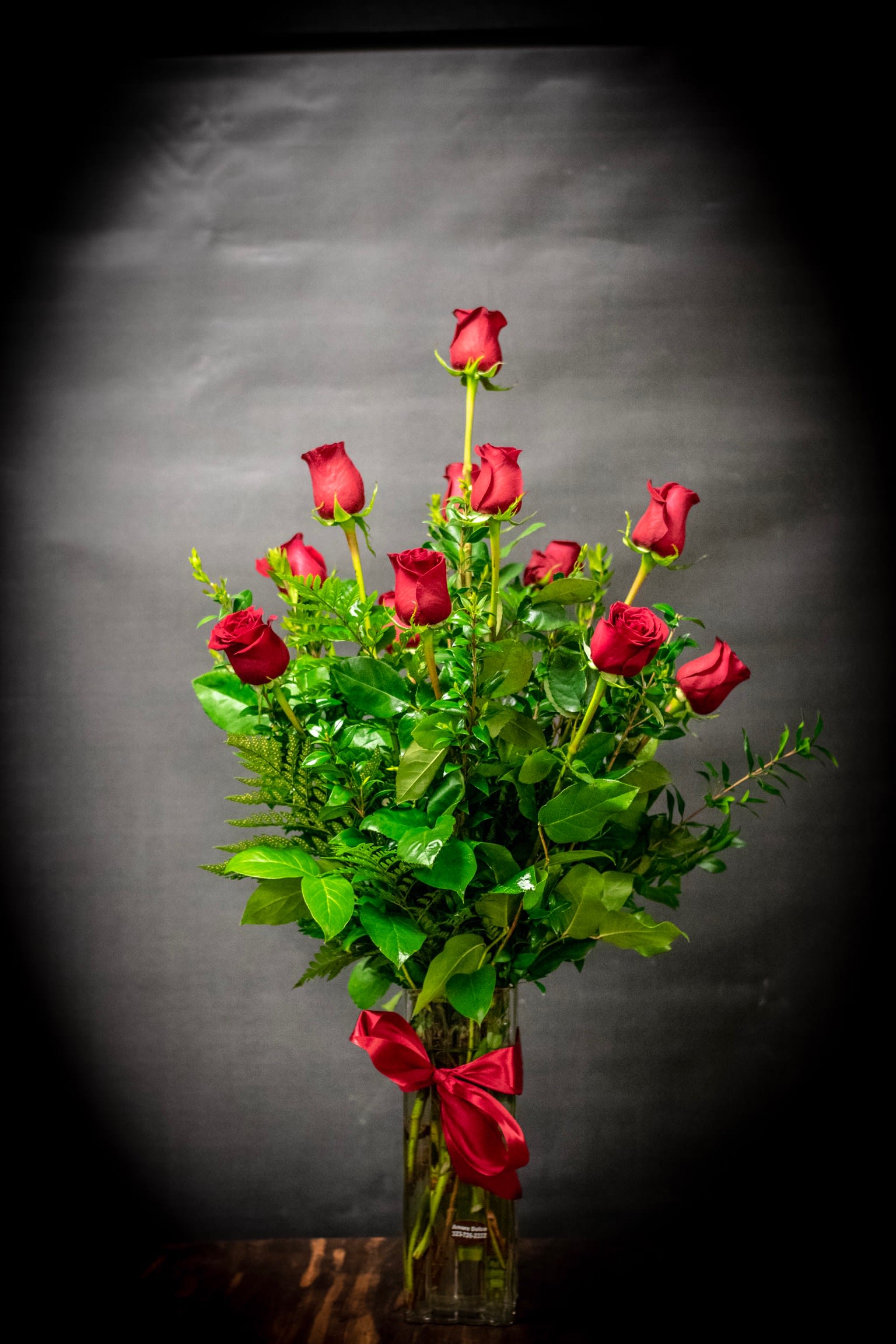 Dozen roses  - One dozen long stem Premium roses with fresh greens in a tall glass cylinder vase.