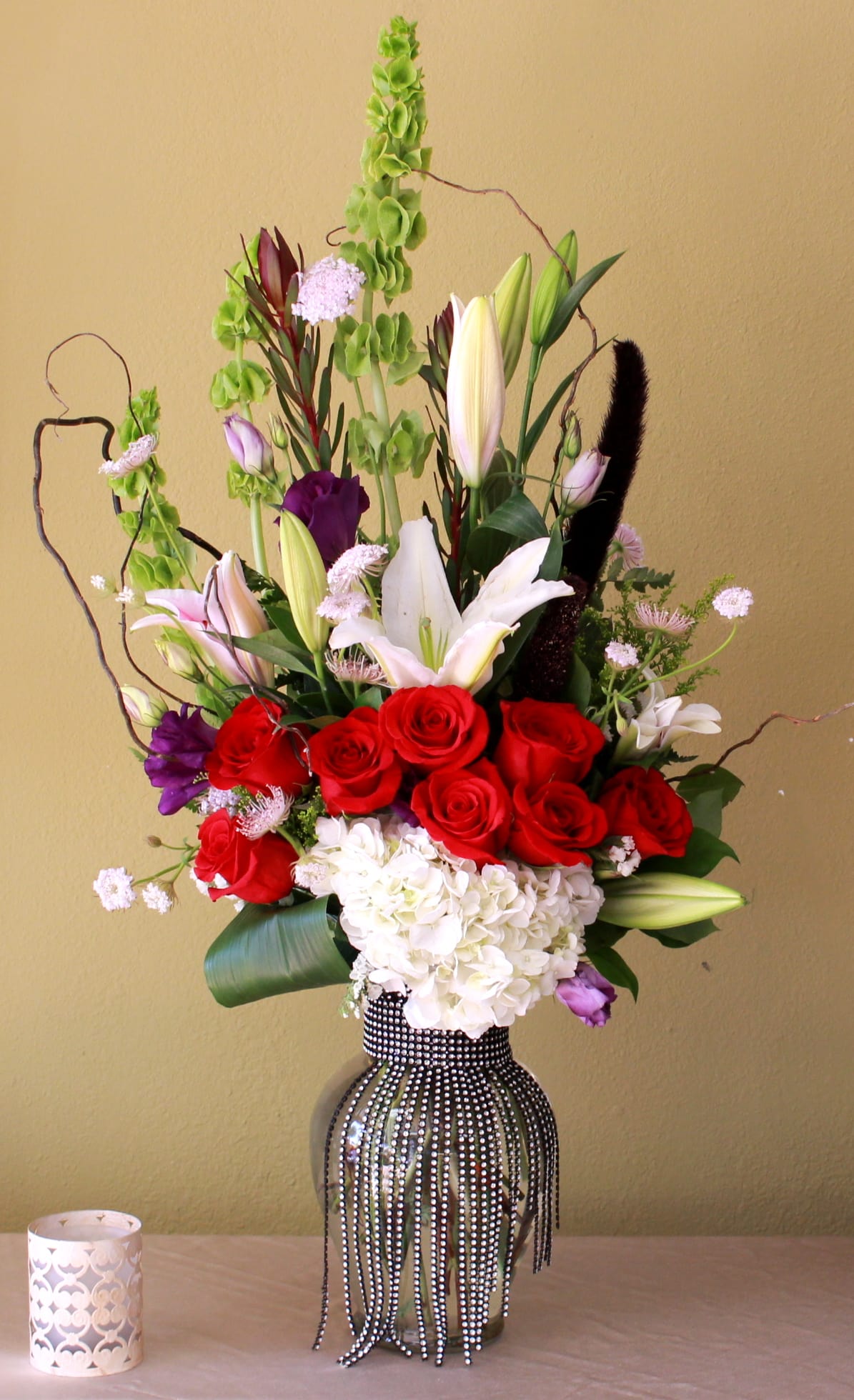 fancy rose bouquet - Stargazer lily's, red roses, bells of Ireland and white hydrangeas in a tall ginger vase with crystals  
