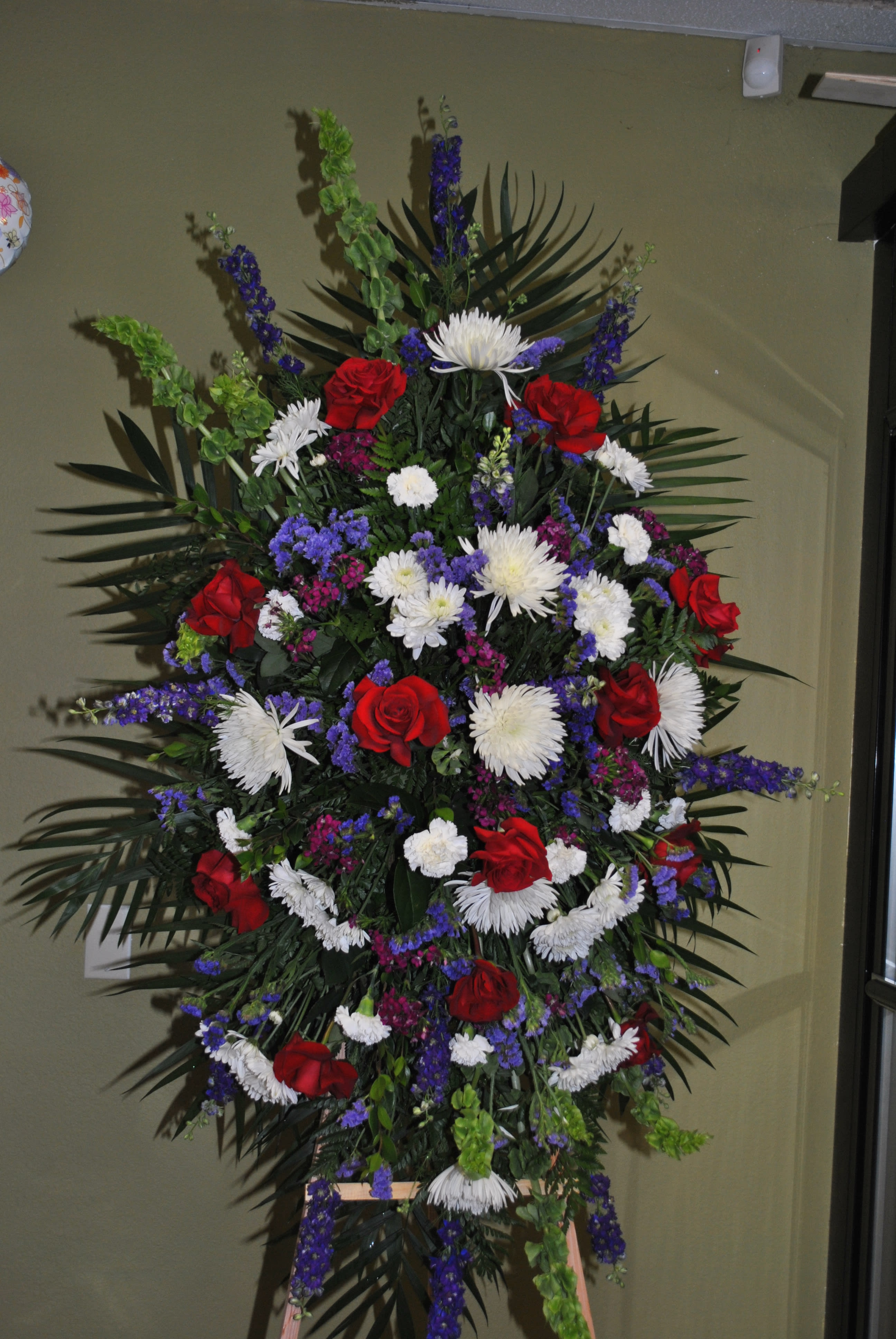sympathy standing spray  - sympathy standing spray red white ad blue. red roses larkspur, spired mums, carnations and statice 