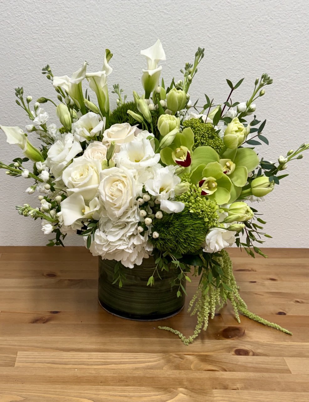 Grand Forest - For an elegant and versatile flower arrangement perfect for any occasion, consider a sophisticated display in a clear cylinder glass vase with a stylish liner. This exquisite arrangement features a harmonious blend of white and green blooms, including lush white hydrangeas, Vibrant green hydrangeas, and Pristine white roses, This chic combination of flowers creates a timeless and graceful aesthetic, making it an ideal centerpiece for any event or a beautiful gift for your loved ones. The opening of the vase is 7".