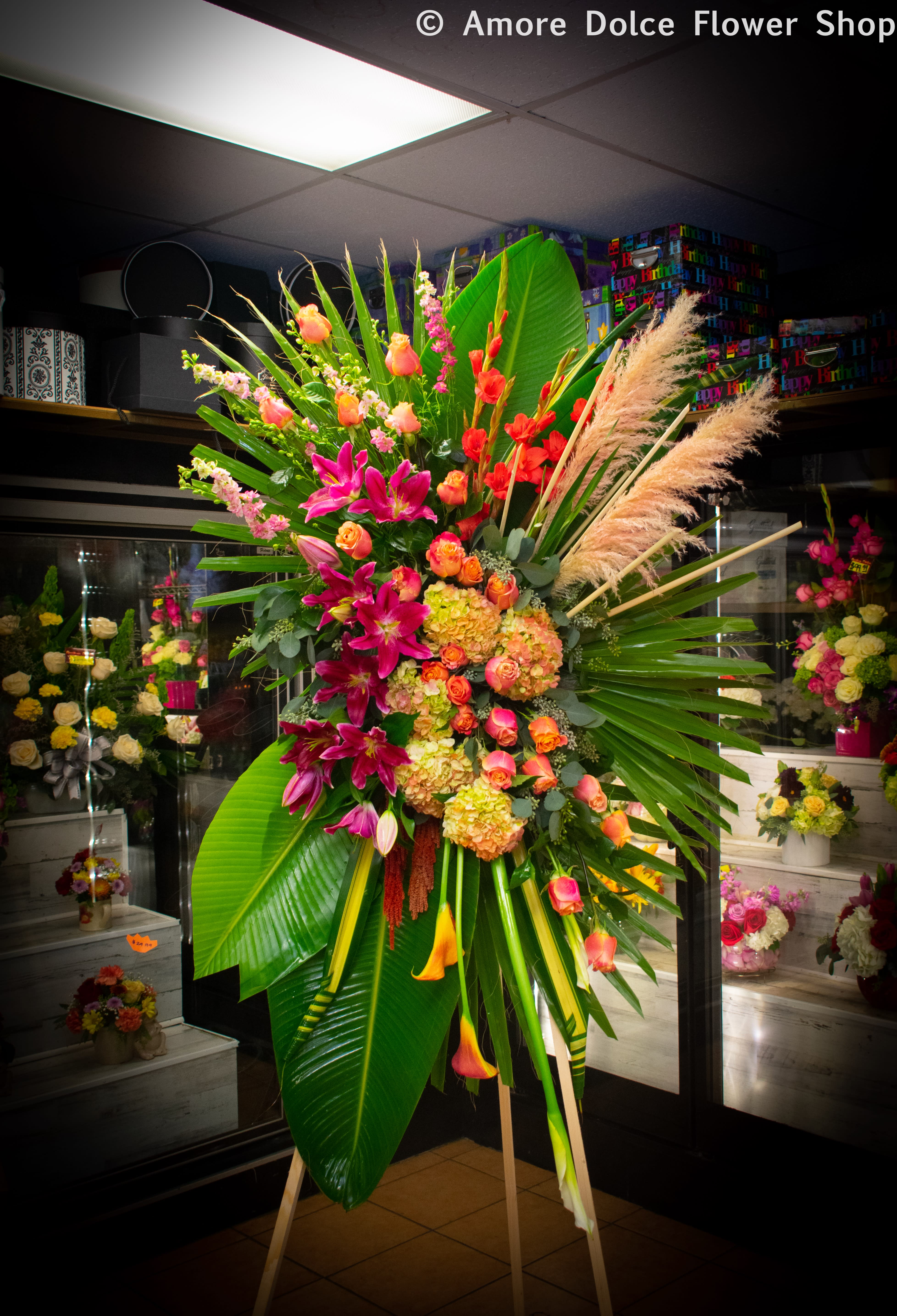 Abstract Tropical Standing Spray - An abstract standing spray with roses,lilies,hydrangeas,Cala lilies, gladiolus,tropical leaves.  ***Please note pompas grass may be replaced with something of the same values. Availability depends on the season. Aphoto is always sent out before delivery.