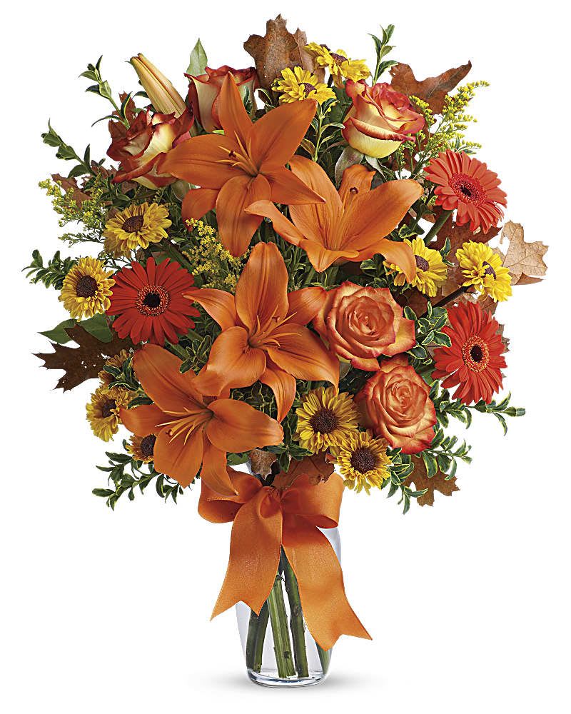 Orange lilies and roses with yellow daisies in a glass vase
