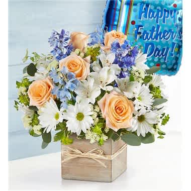 Peach roses and white daisies in a wooden box with a Father's Day balloon.