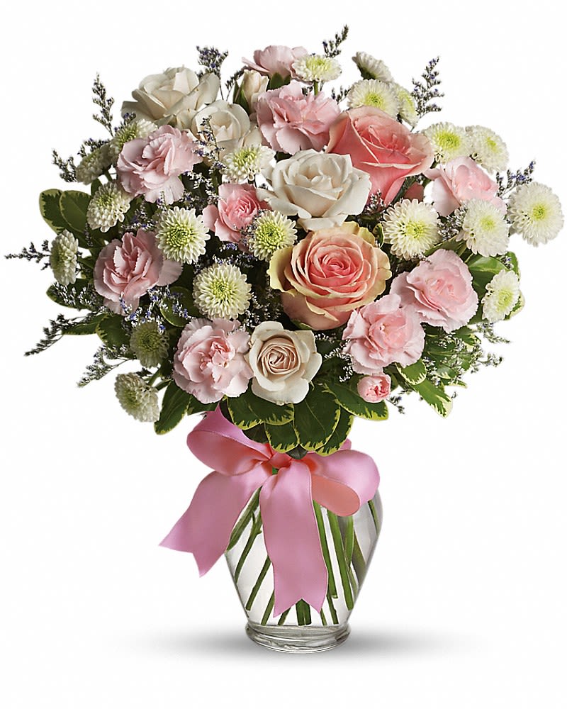 Pink and white bouquet in a glass vase with a pink ribbon
