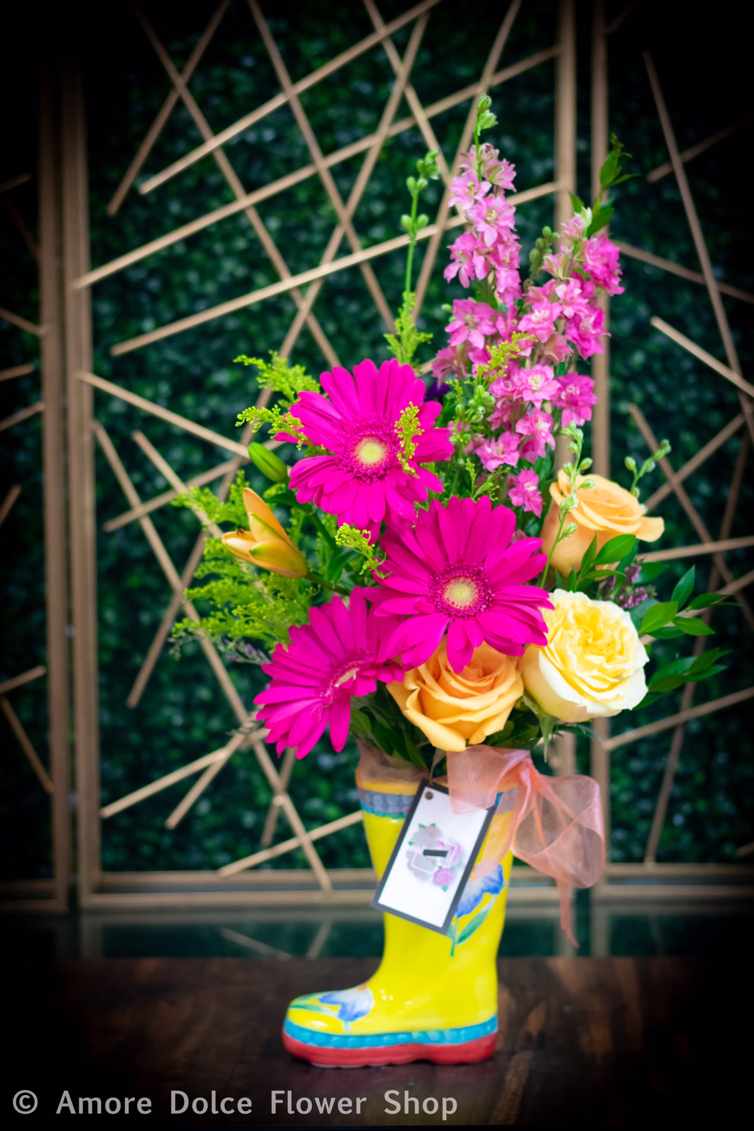 Garden of Gerbers - Gerber daisies and roses along with other seasonal flowers arranged in a cute ceramic rain boot. 