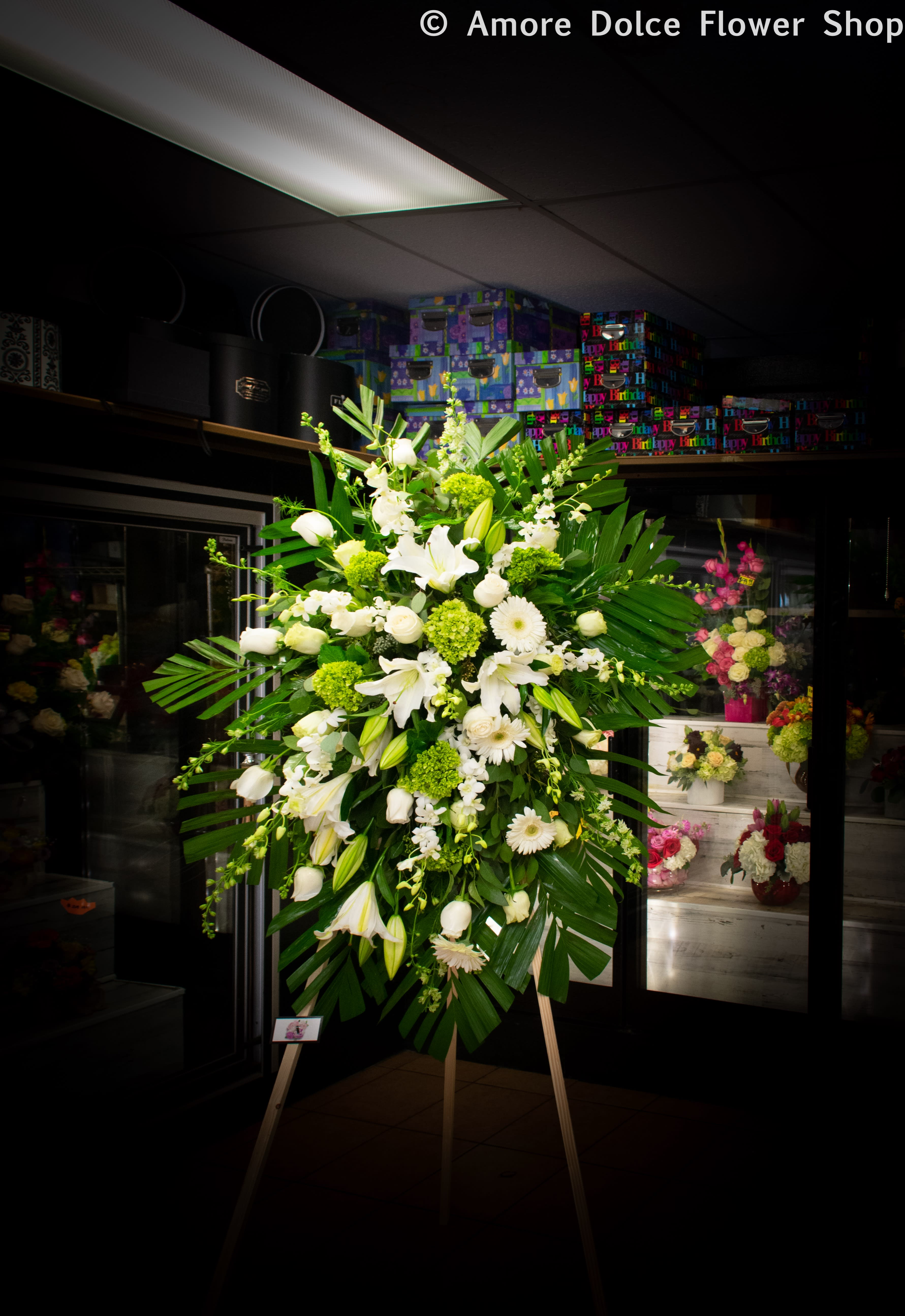 Large white and green standing floral spray on an easel