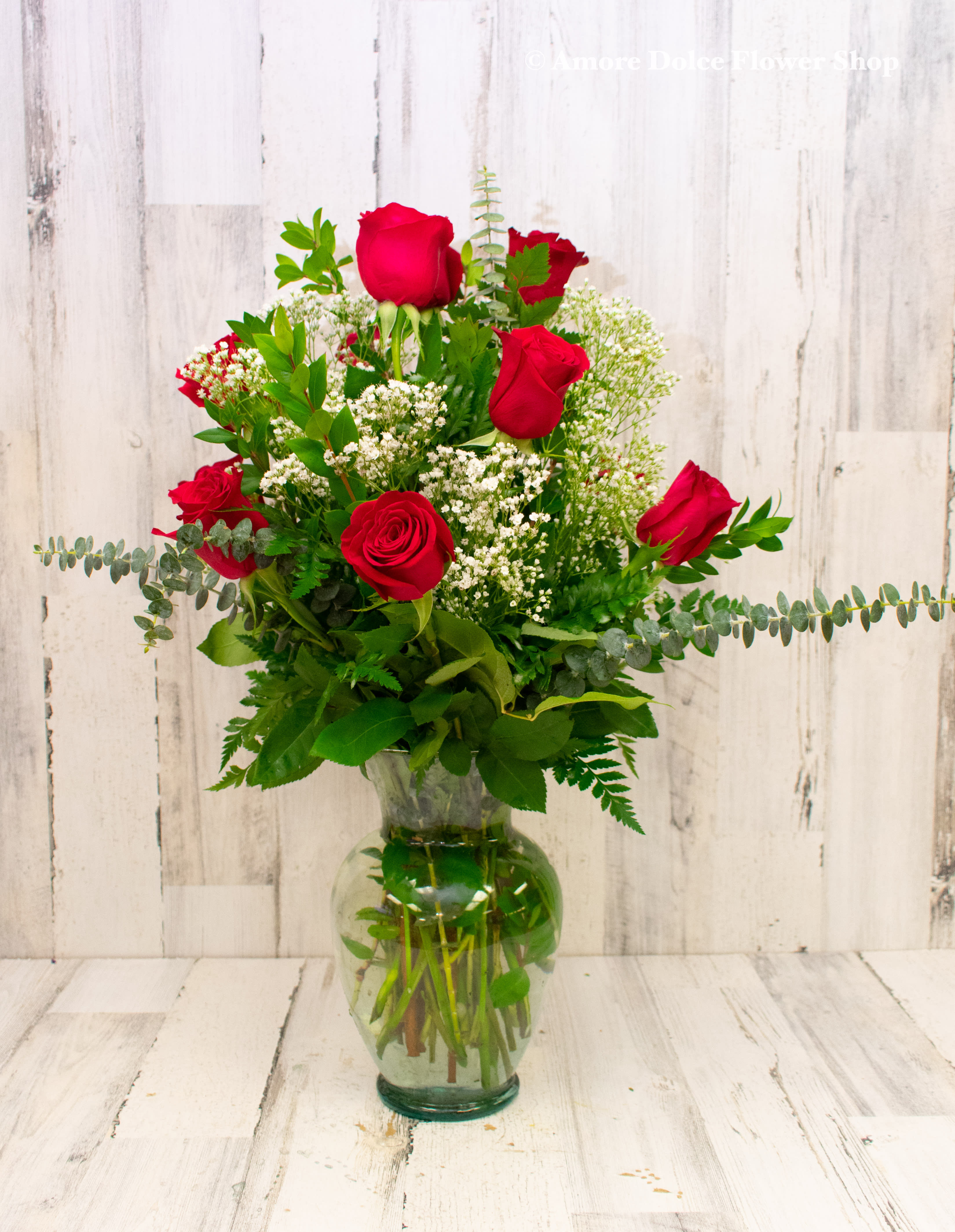 A Dozen Deluxe Roses - For the perfect, traditional Valentine’s Day bouquet – or for a birthday, anniversary or other special day – this bouquet of a dozen red roses adorned with a classic mix of white baby’s breath and ferns is a classic gift of love. Send it today, and she’ll love you forever. Available in many colors.