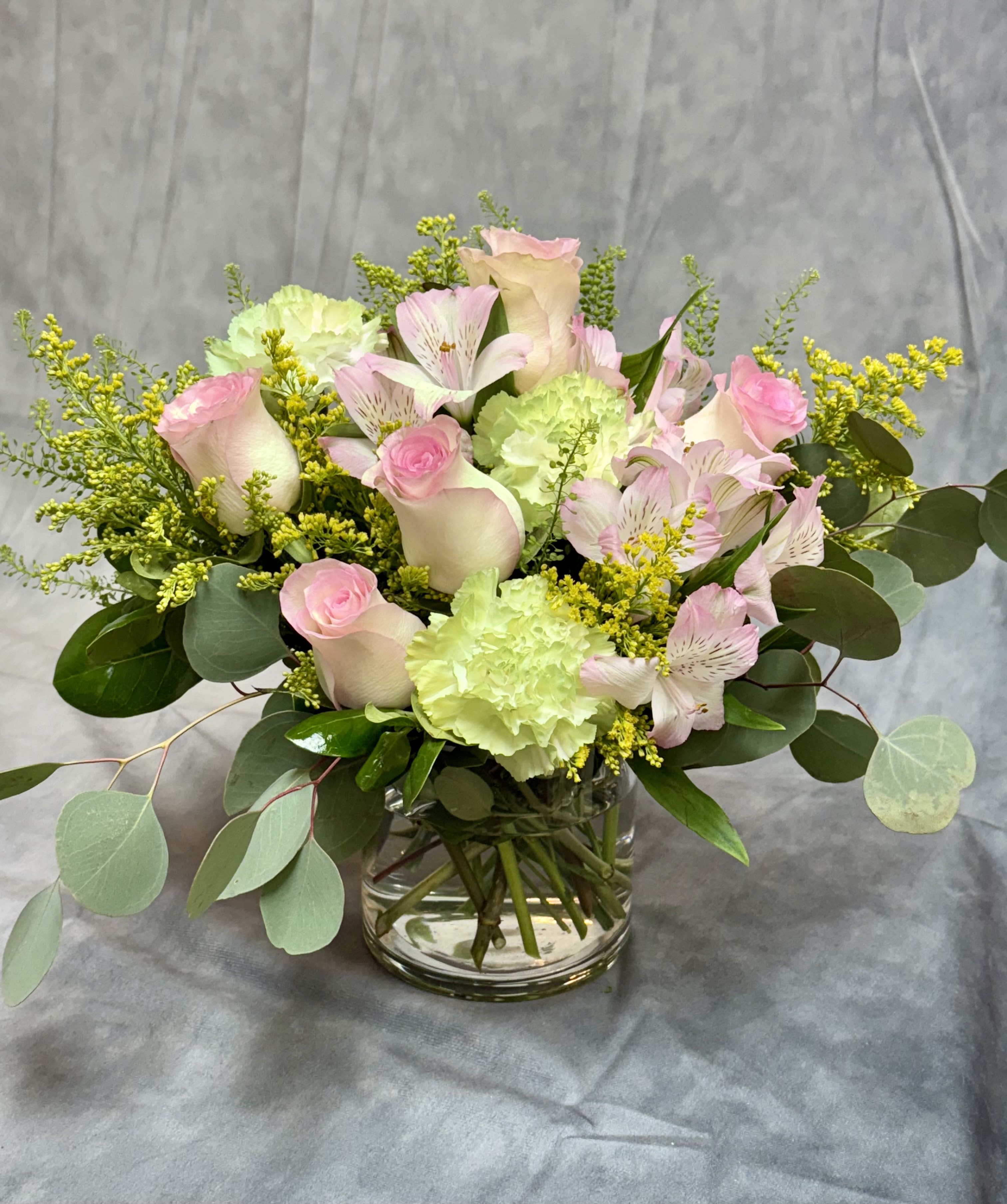 Pink roses and pale green carnations in a glass vase