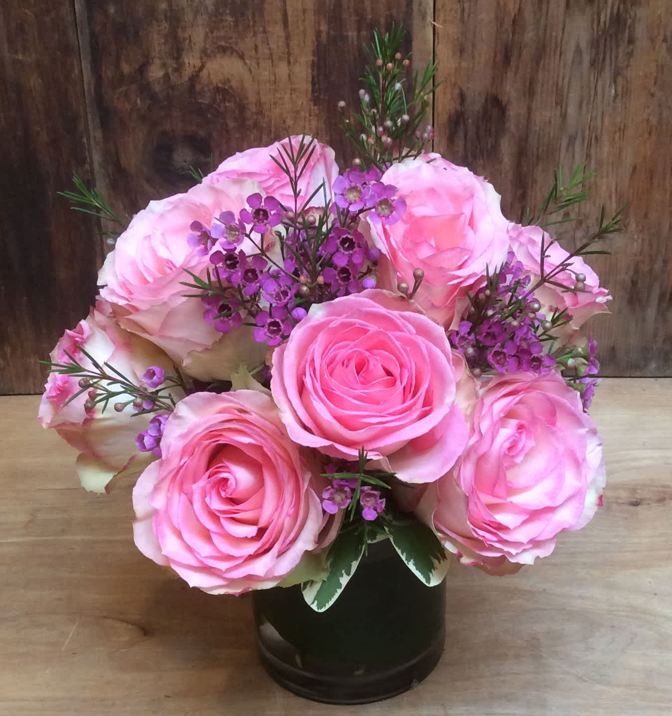 Emma - An entirely feminine and rather modern take on the classic dozen roses, this innocent bouquet of large headed cabbage   roses is simply breathtaking. A versatile choice for an anniversary or anytime you want to send your very best. Esperance Roses and accents are arranged with a modern feel in a leaf wrapped vase.