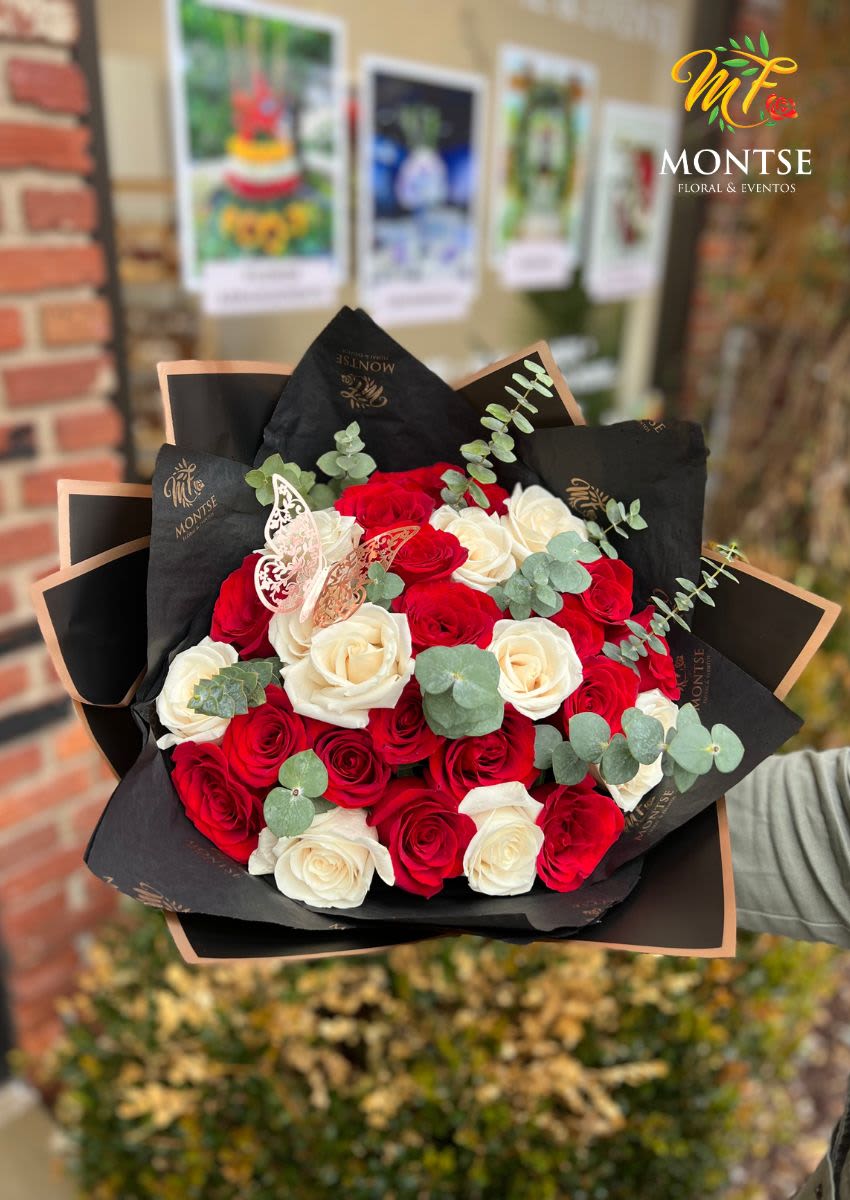 Bouquet of red and white roses with eucalyptus in black wrap