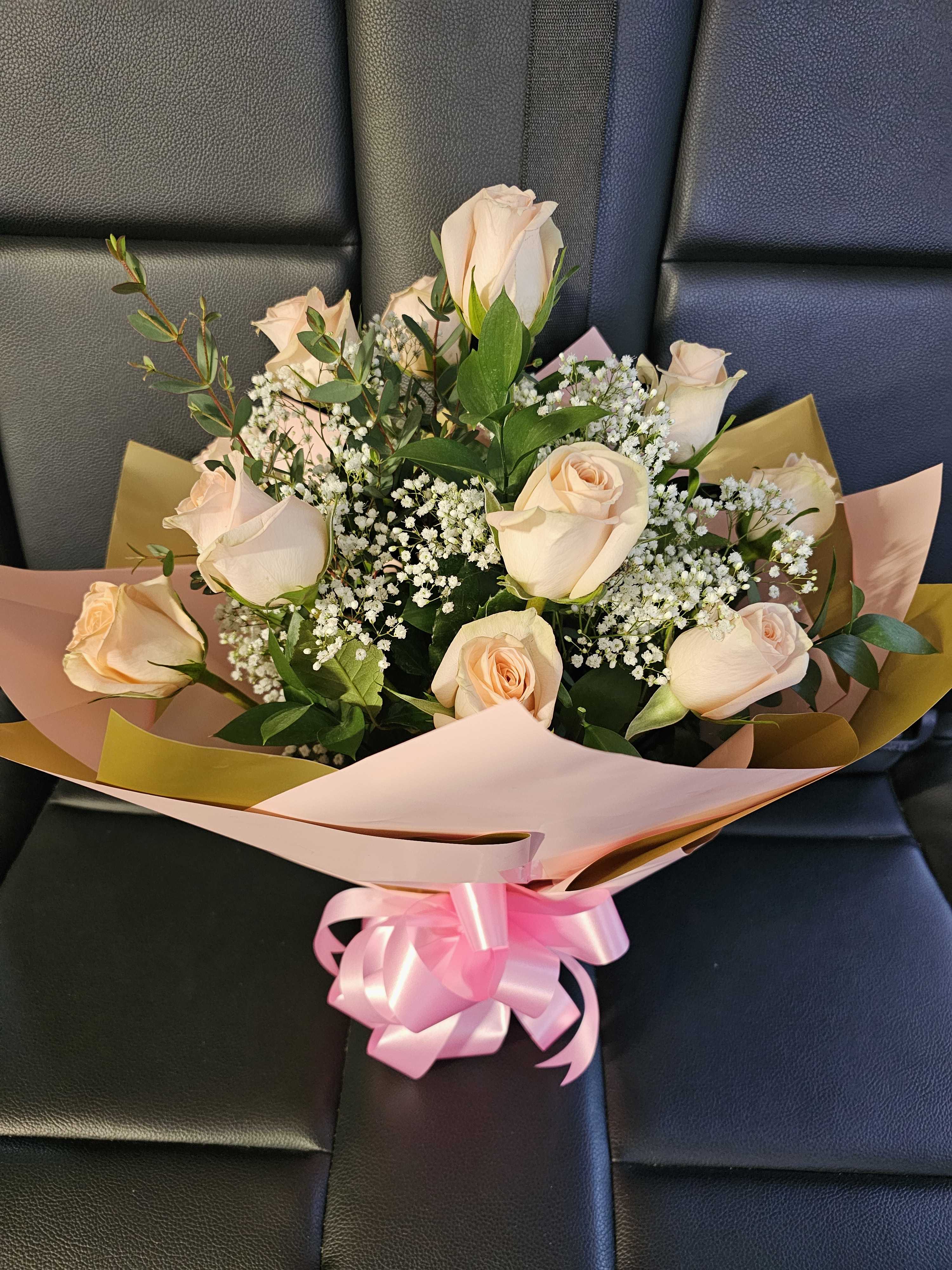 Bouquet of pale peach roses with baby's breath and pink ribbon