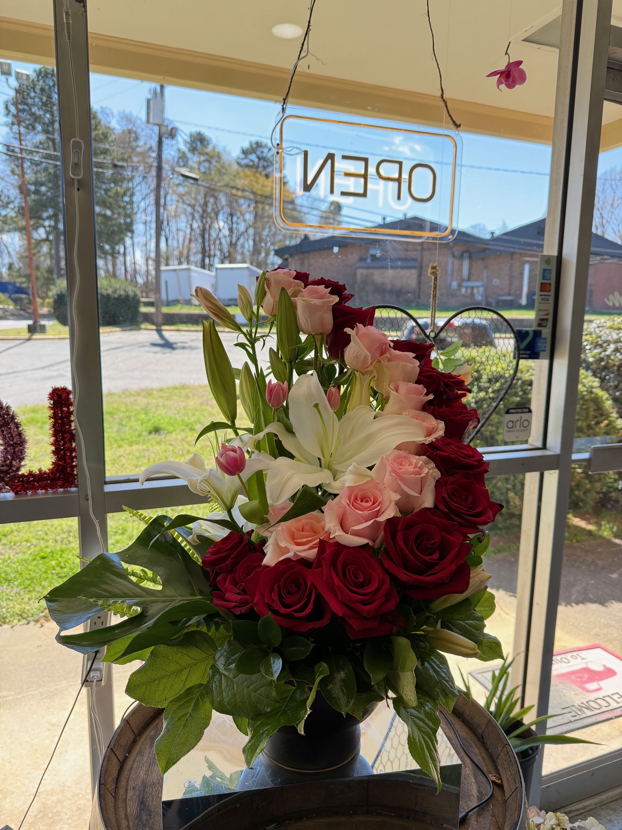 Bouquet of red and pink roses with white lilies in a black vase