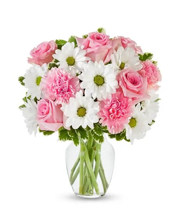 Pink roses and carnations with white daisies in a clear glass vase