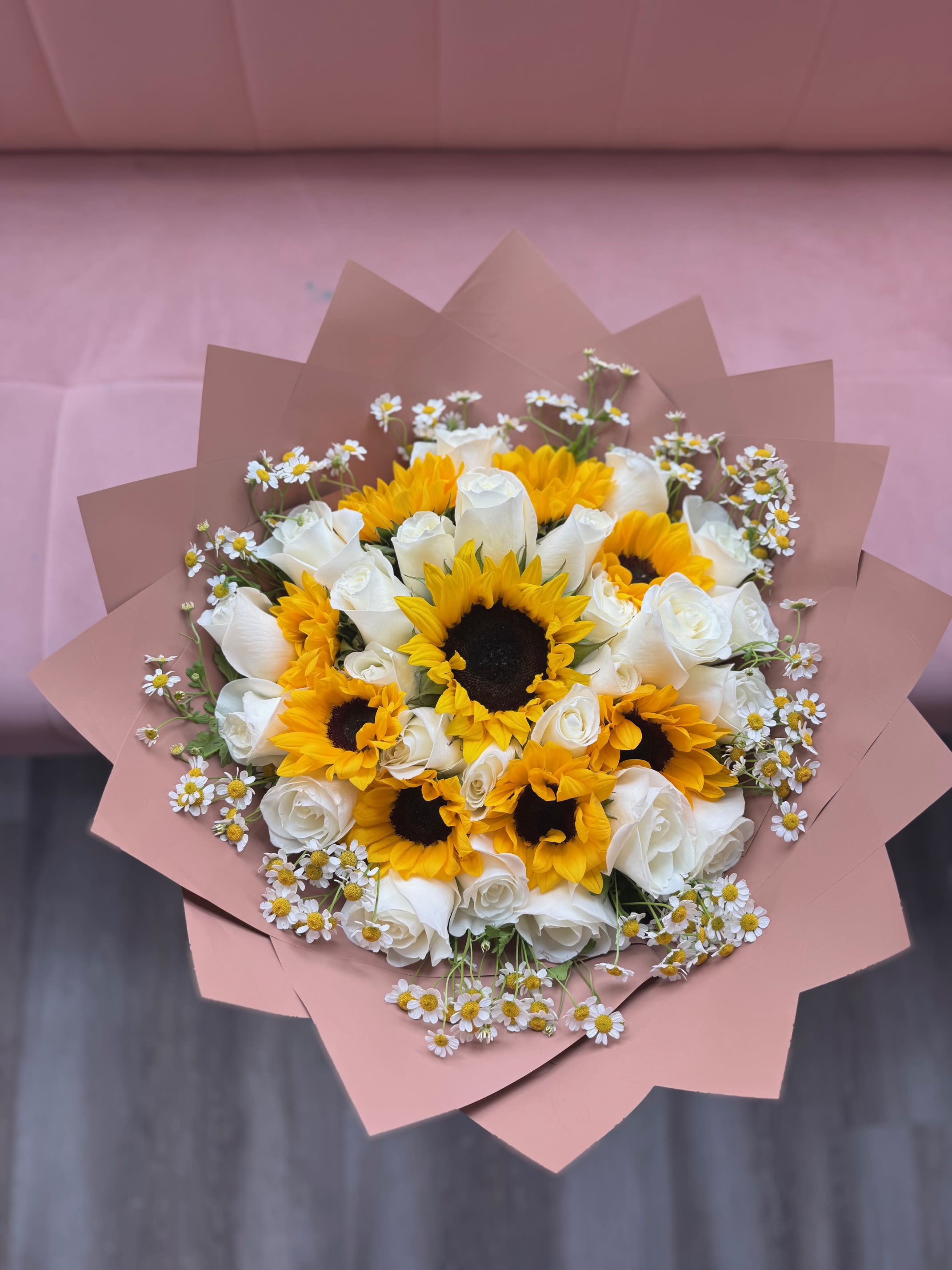 Bouquet of white roses and yellow sunflowers with small daisies