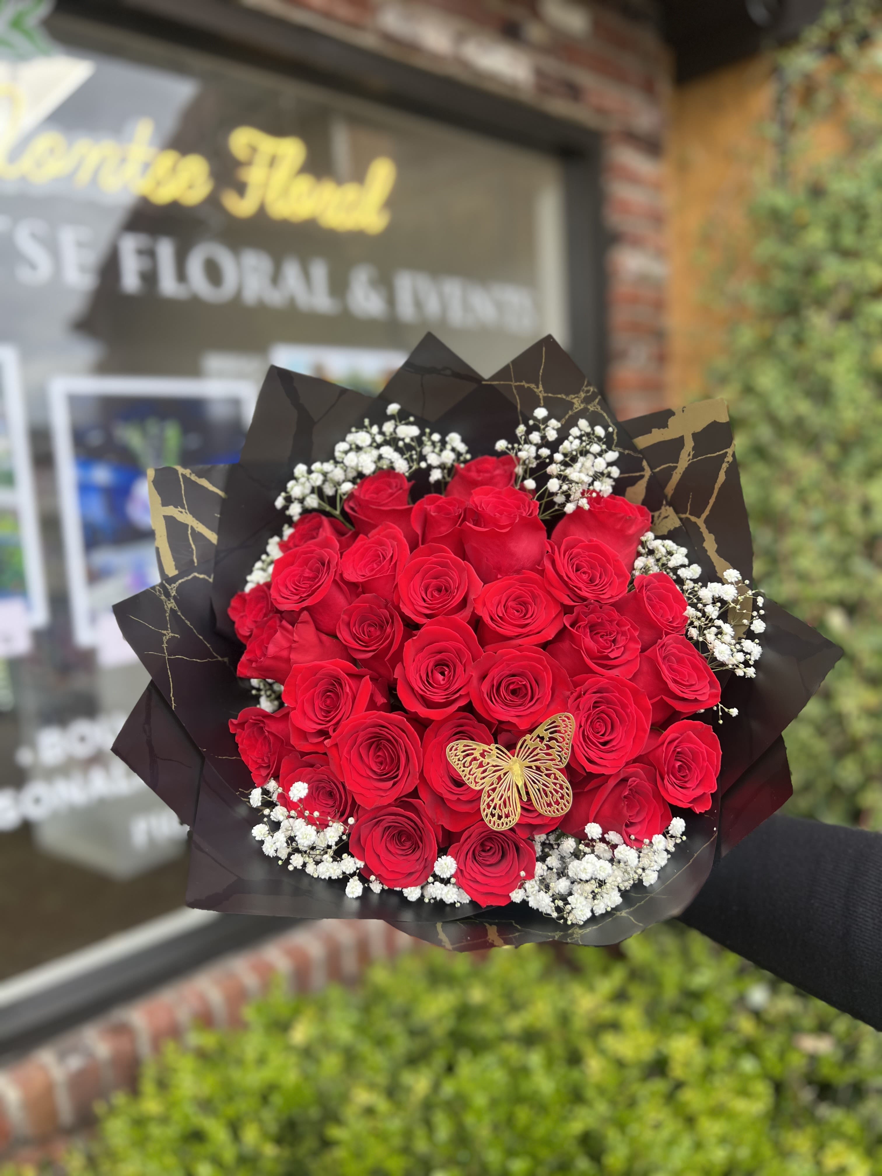 Bouquet of red roses with baby's breath in black wrap
