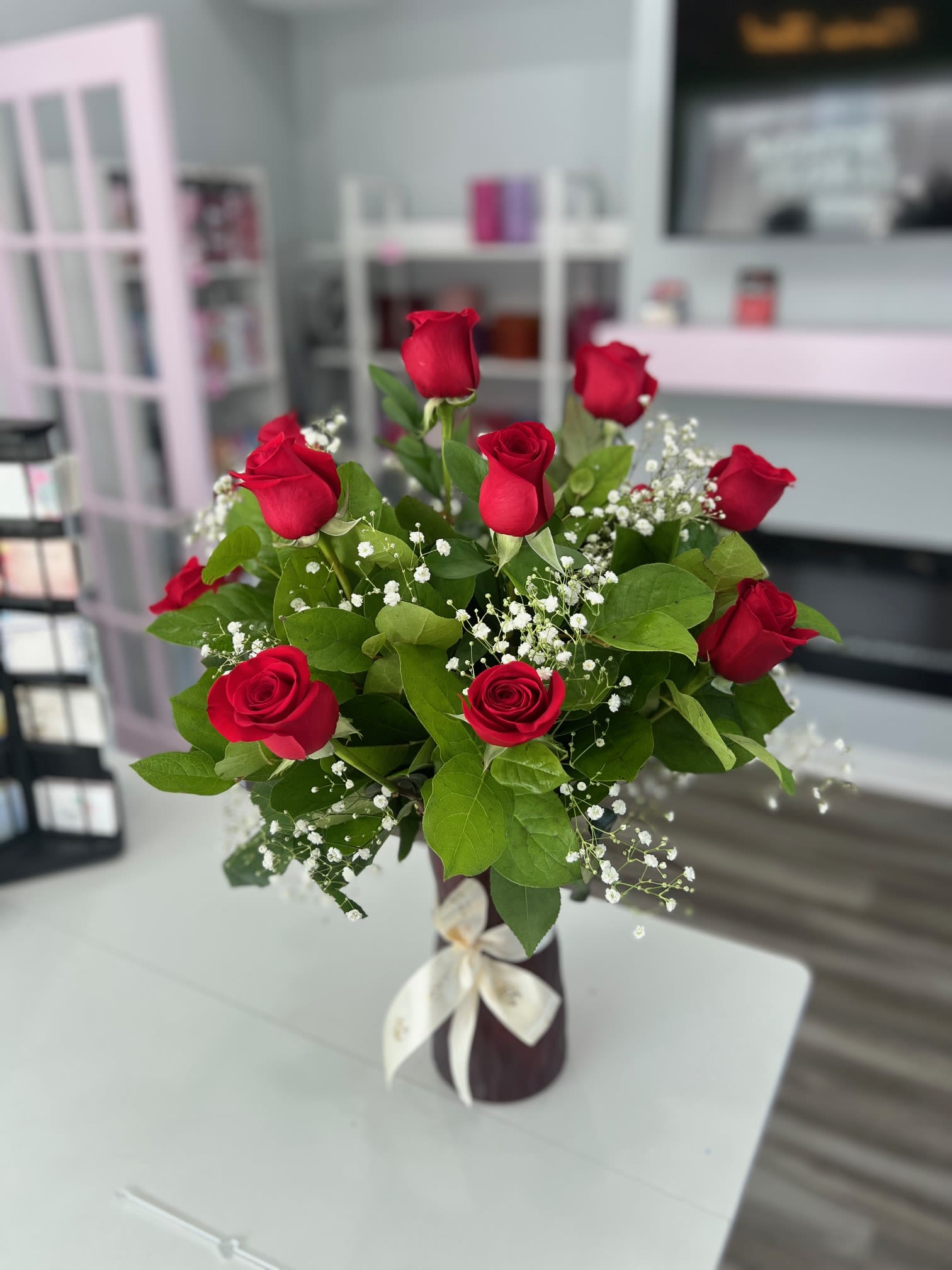 Red roses arranged in a vase with baby's breath