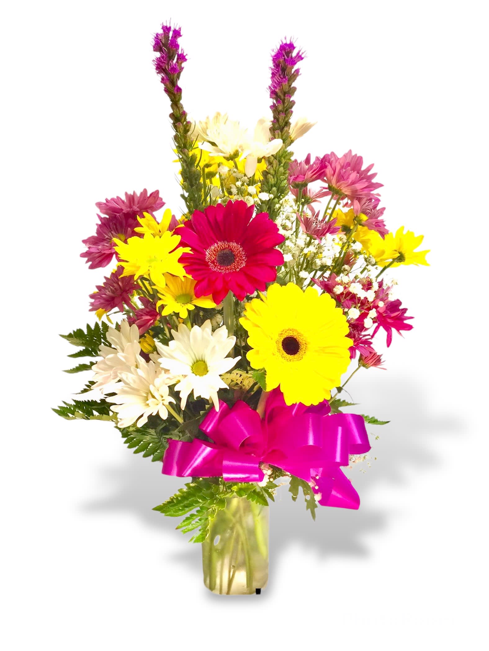 Mixed bouquet of bright daisies in a glass vase with a pink ribbon