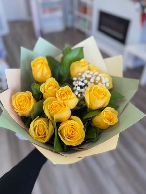 Bouquet of yellow roses wrapped in pastel paper