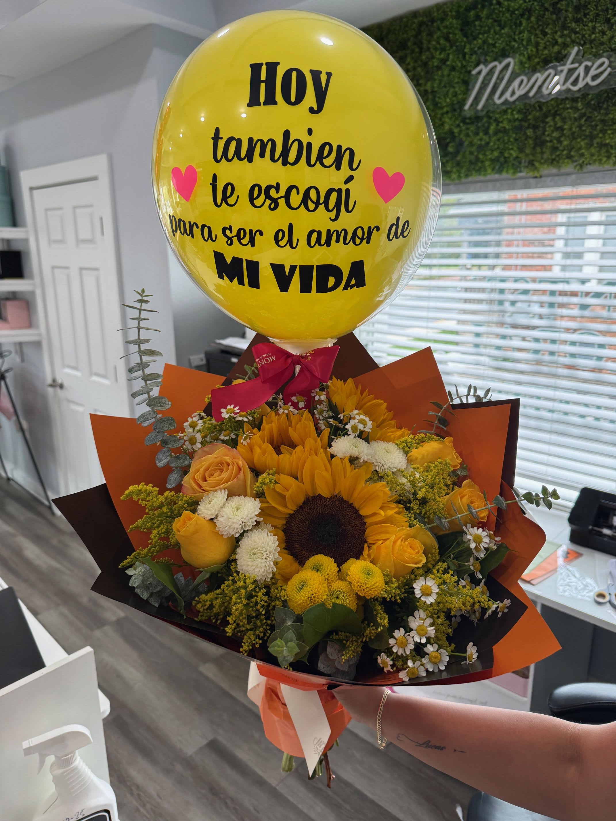 Yellow balloon above a bouquet of sunflowers and roses