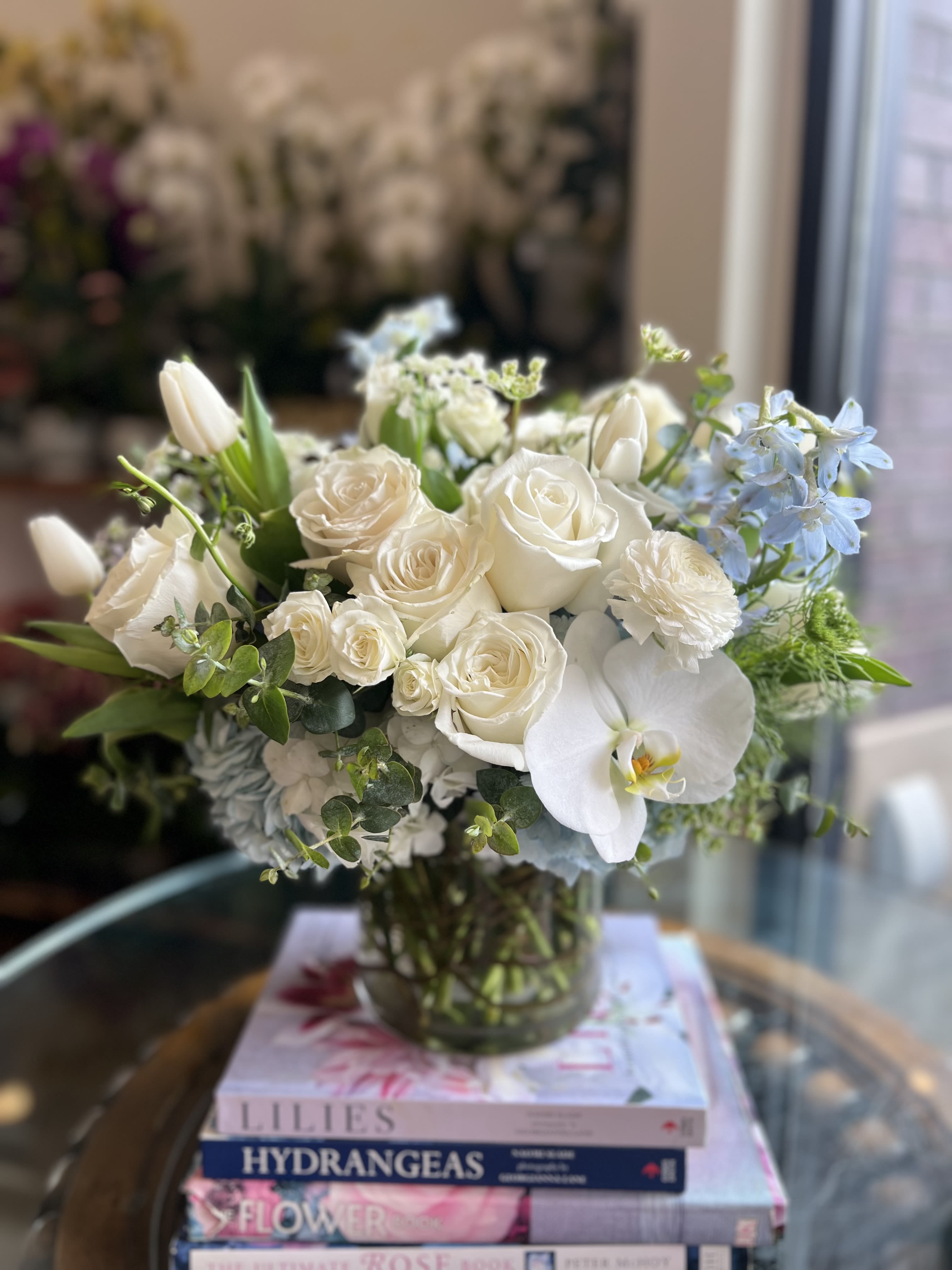 Spring Refresh  - Flowers: white playa blanca roses, white phalaenopsis orchids, white tulips, white spray roses, light blue delphinium, light blue hydrangea, orlaya and baby blue eucalyptus.  