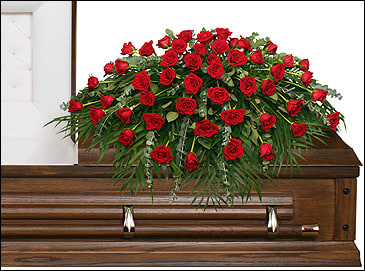 Red rose casket spray on a wooden casket