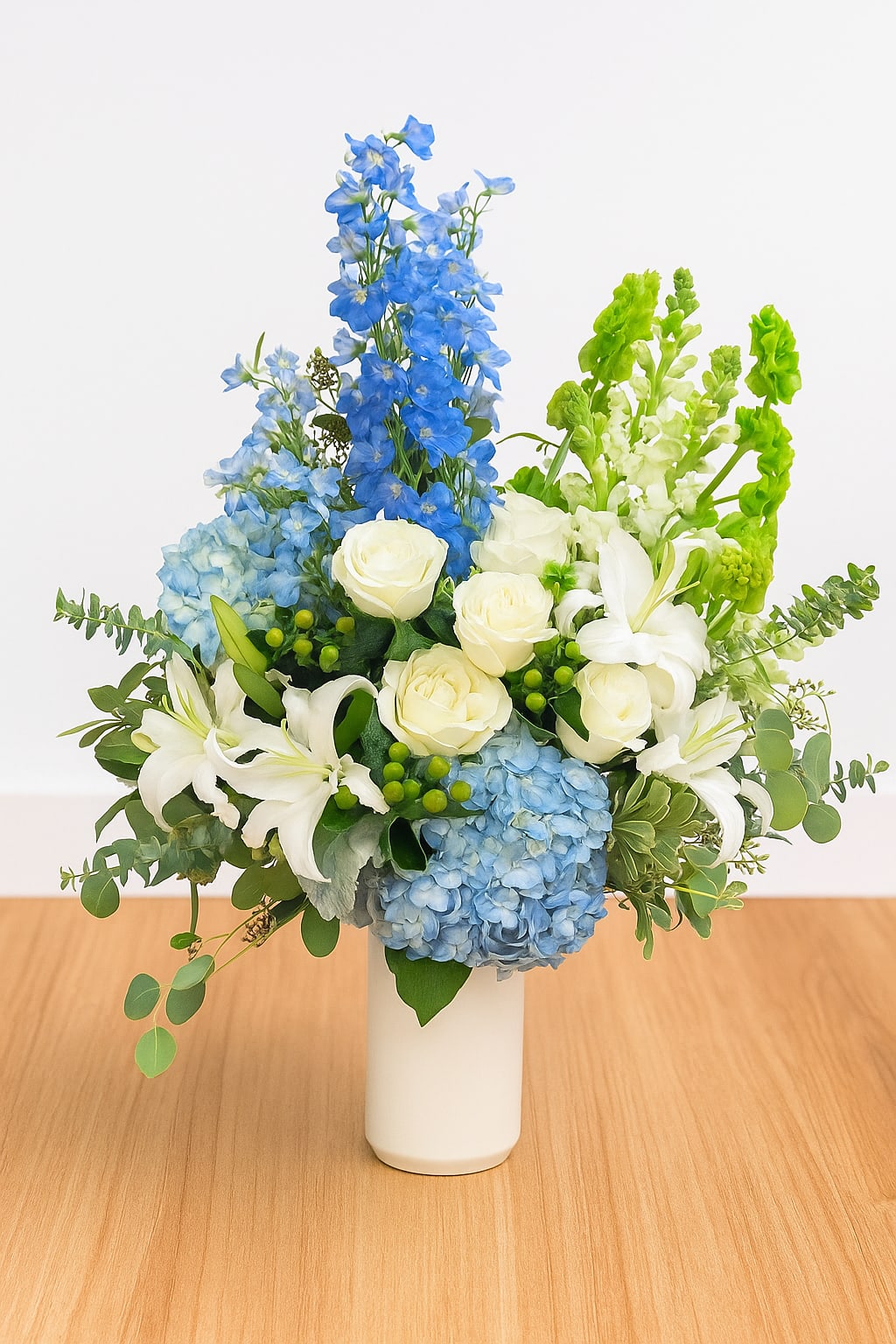 Blue and white floral arrangement in a white vase