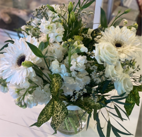 White mixed bouquet with gerbera daisies and roses in a clear vase