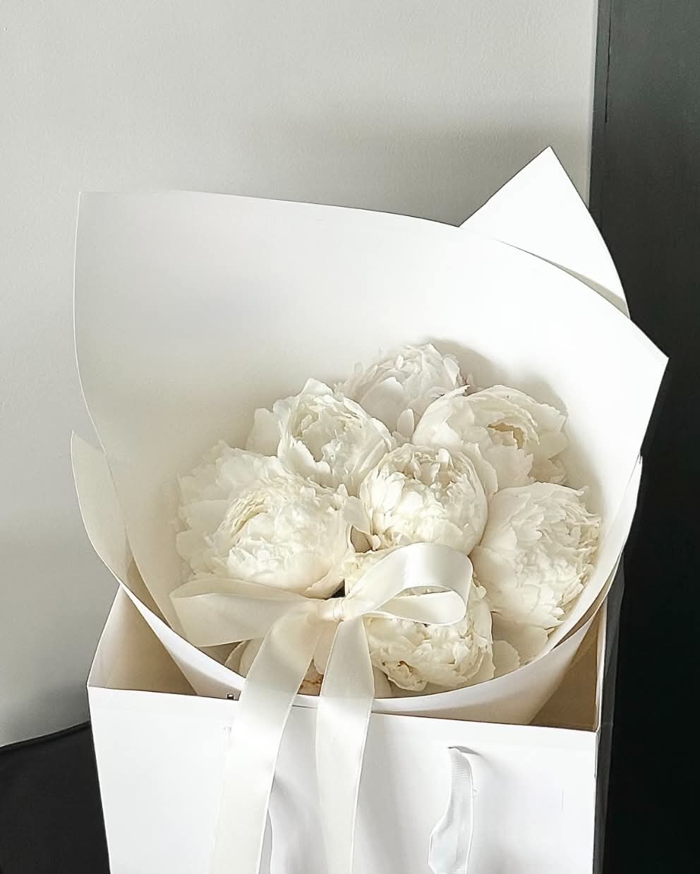 White Peonies to Make Your Day - A refined blend of textures: cloud‑soft white peonies wrapped in crisp white paper. A bouquet that feels both modern and timeless.