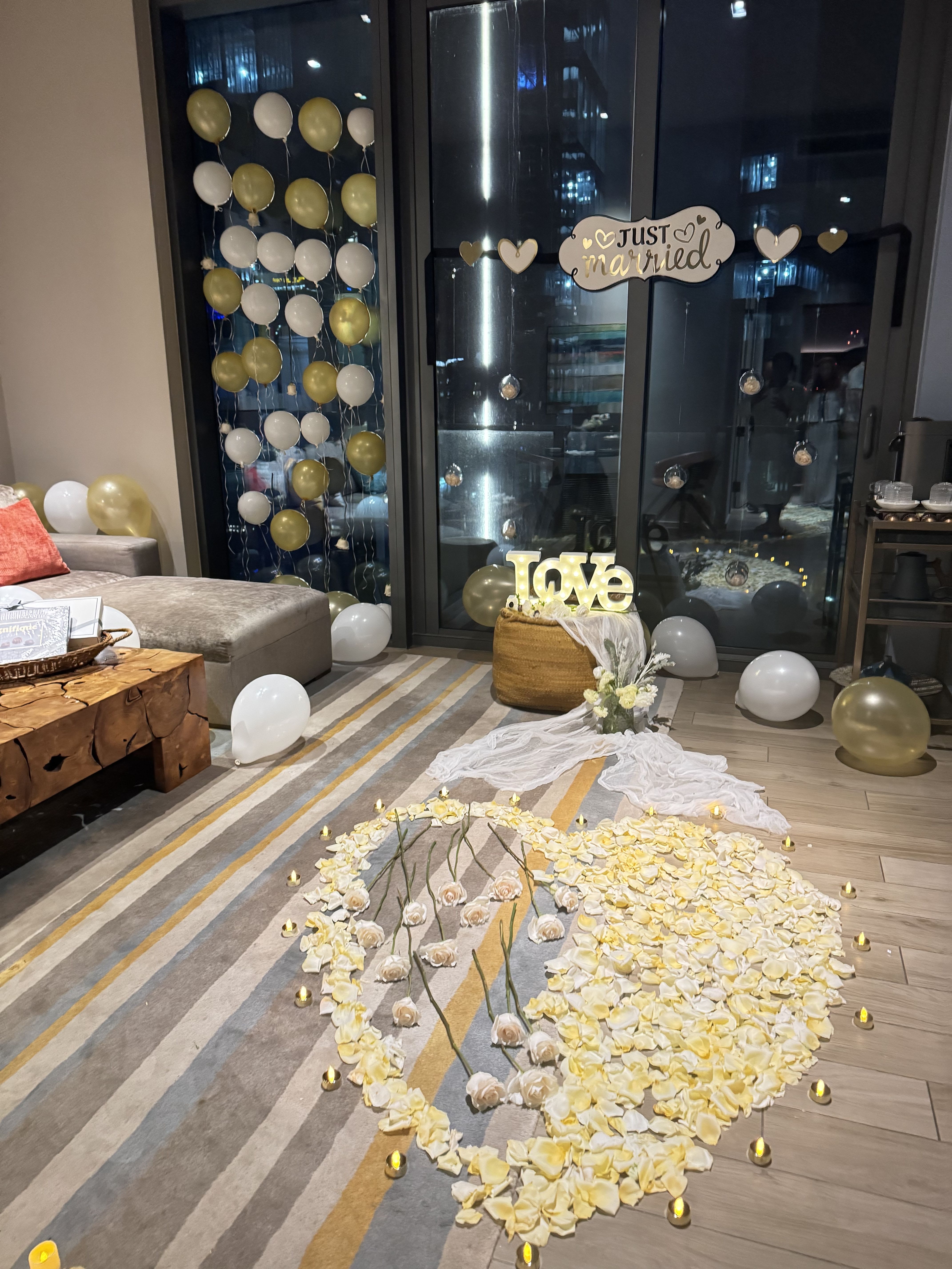 Wedding floor display with white and gold balloons and flower petals