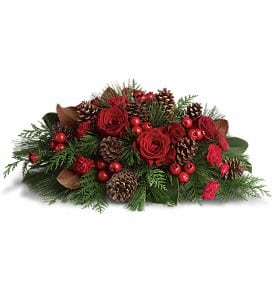 Low red rose and carnation centerpiece with pinecones, red berries, and evergreen branches