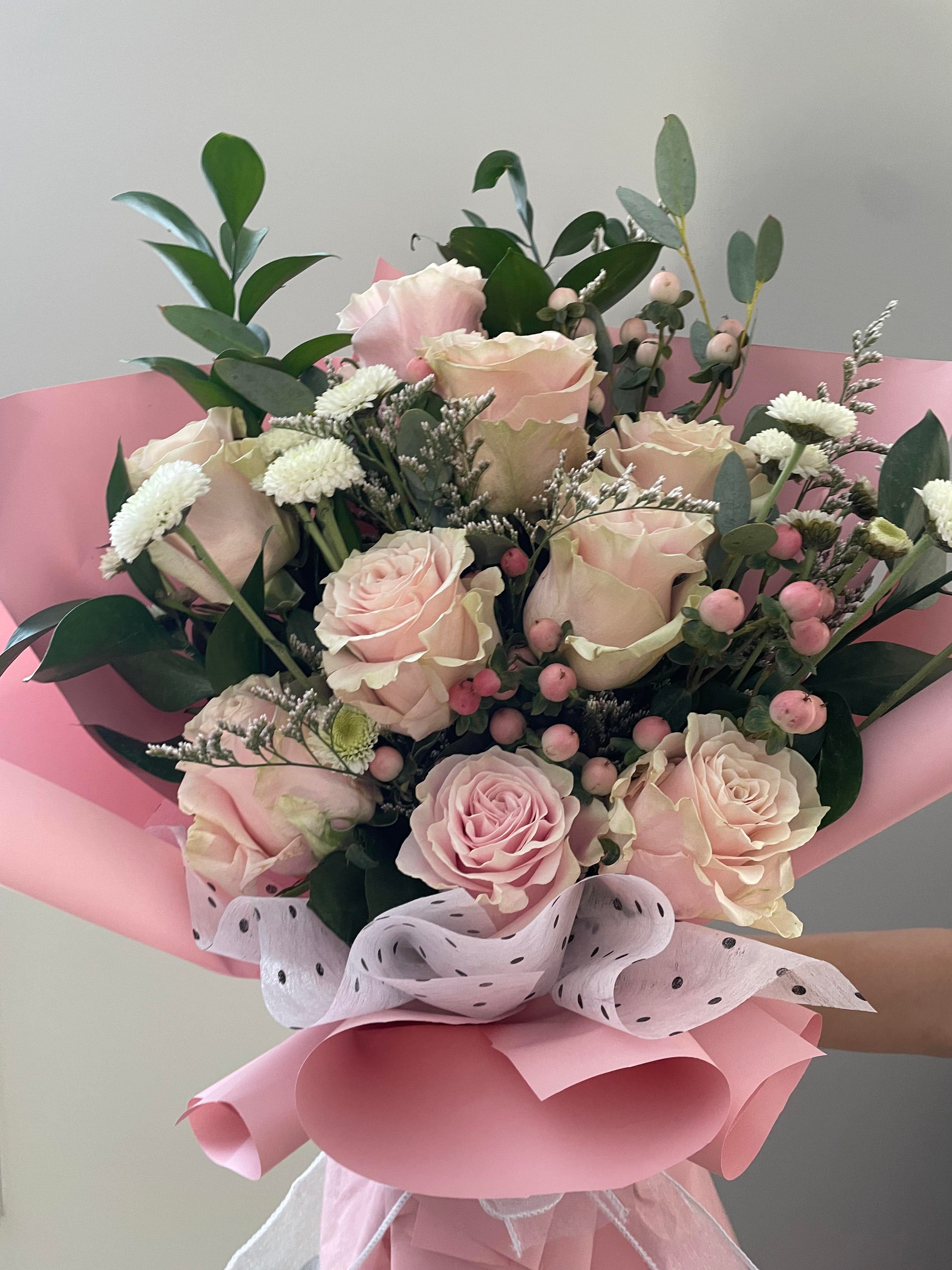 Pink rose bouquet with white filler flowers and pink wrapping
