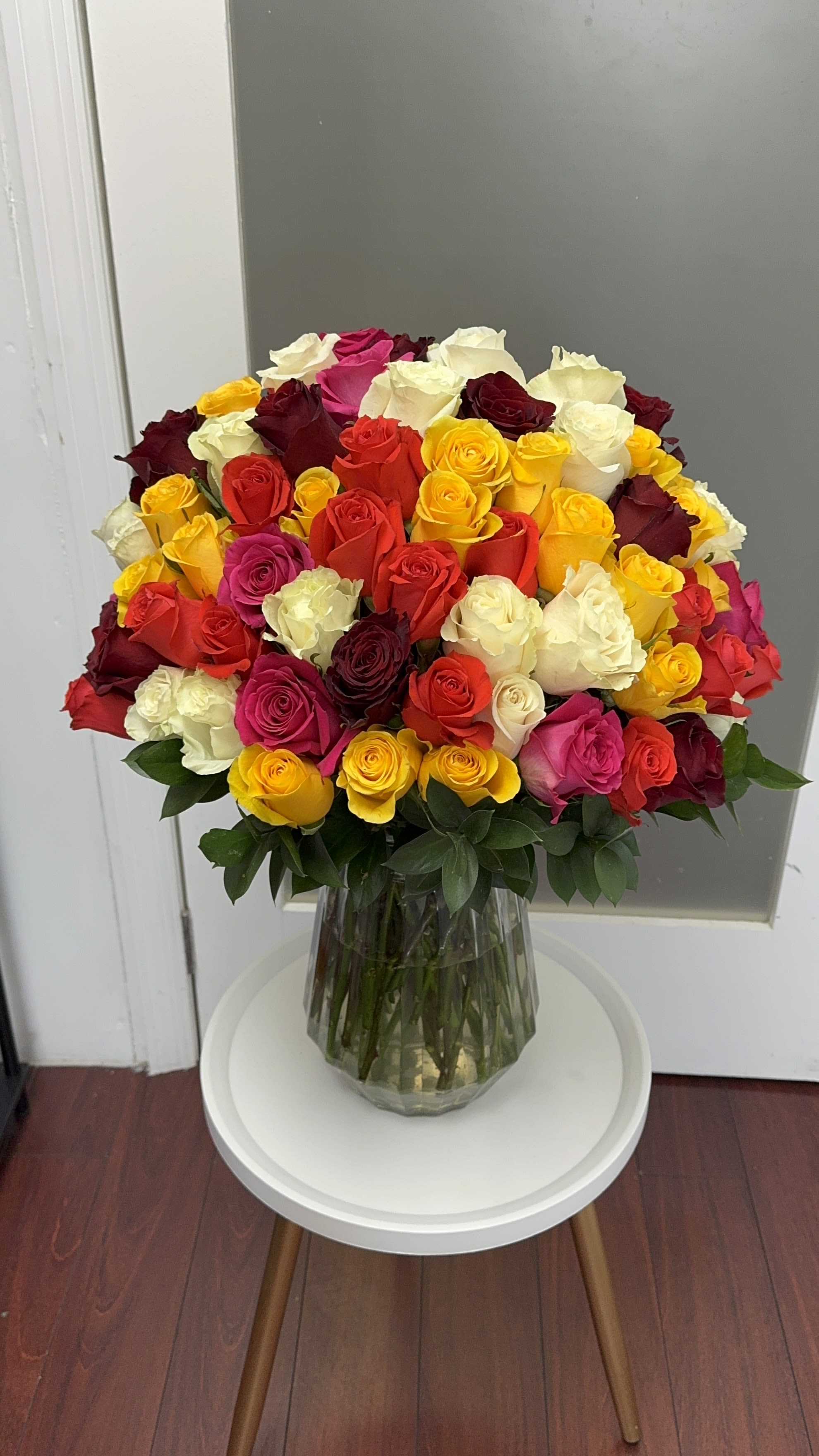 Large bouquet of multicolored roses in a clear glass vase