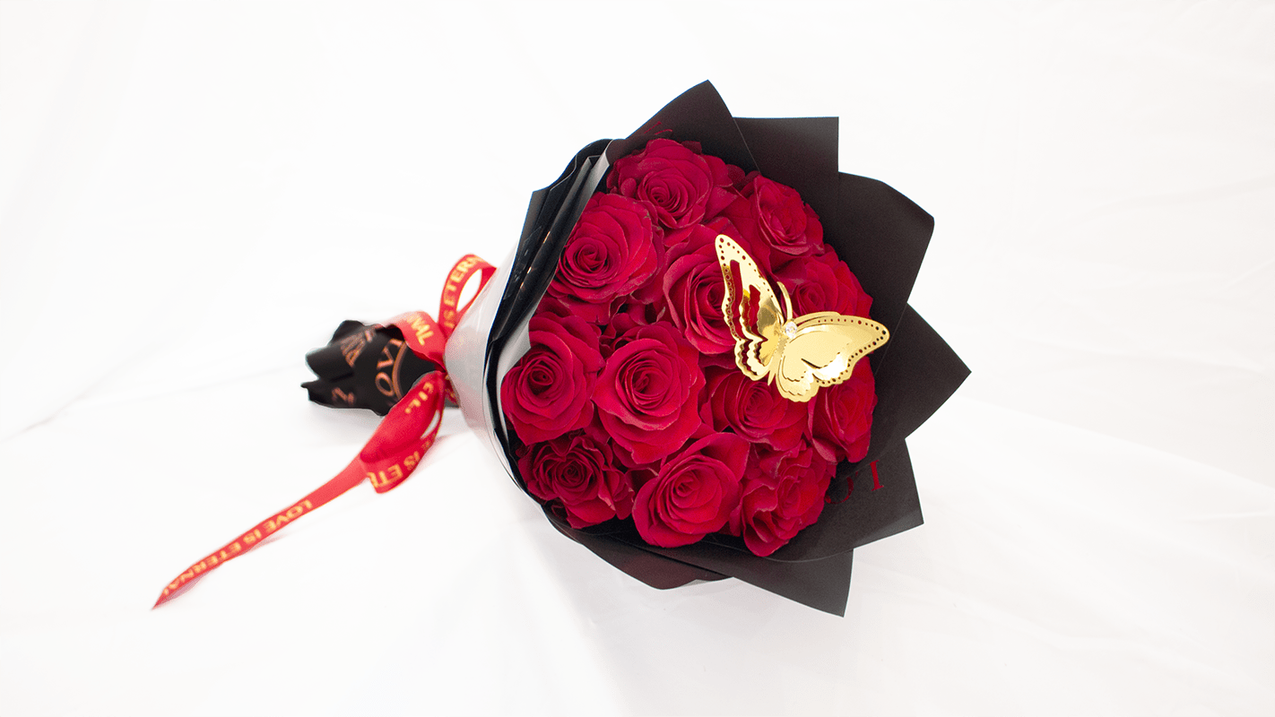 Bouquet of red roses wrapped in black paper with a butterfly decoration