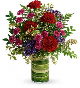 Mixed red and purple flowers in a green striped glass vase