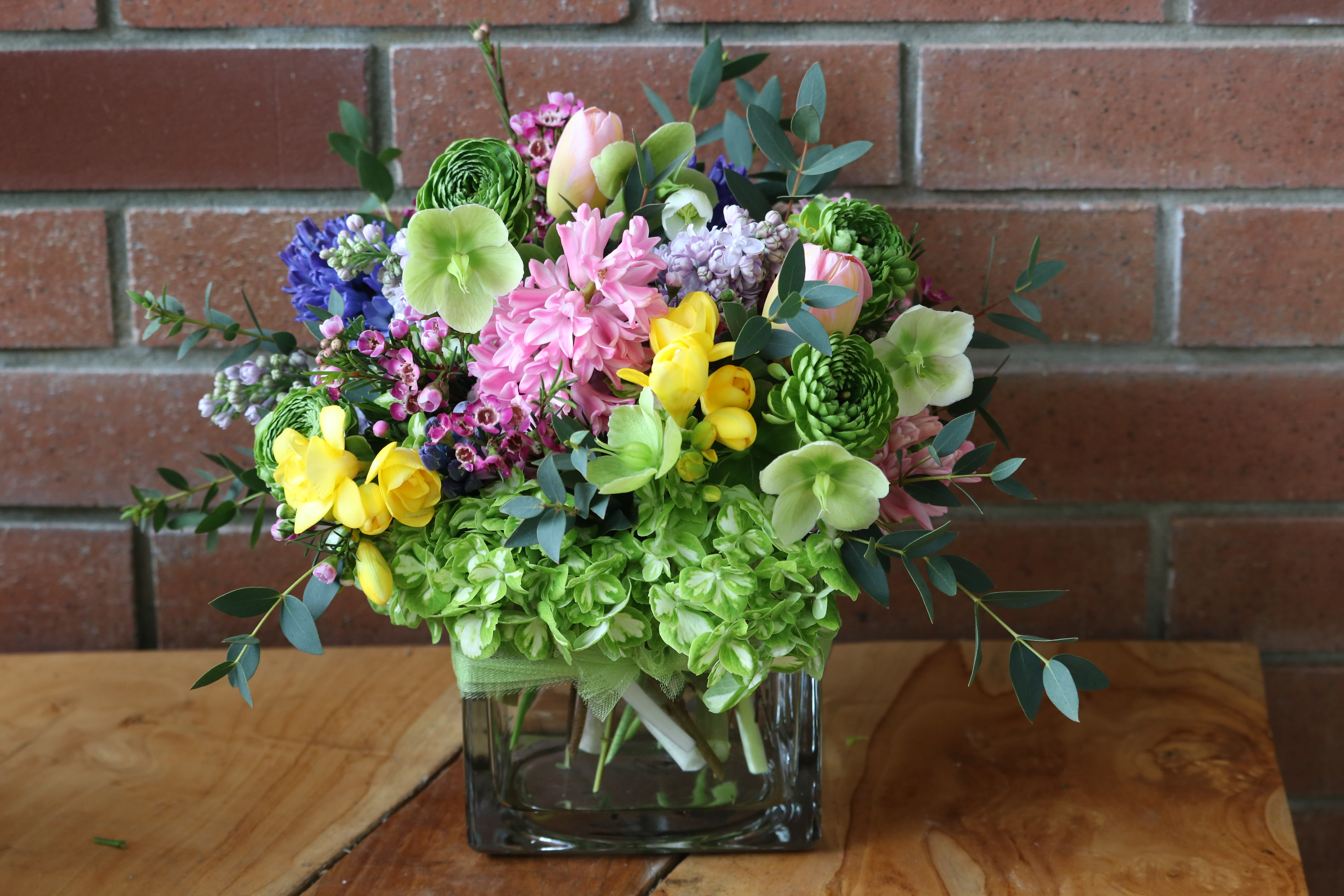 Colorful mixed bouquet in a square glass vase