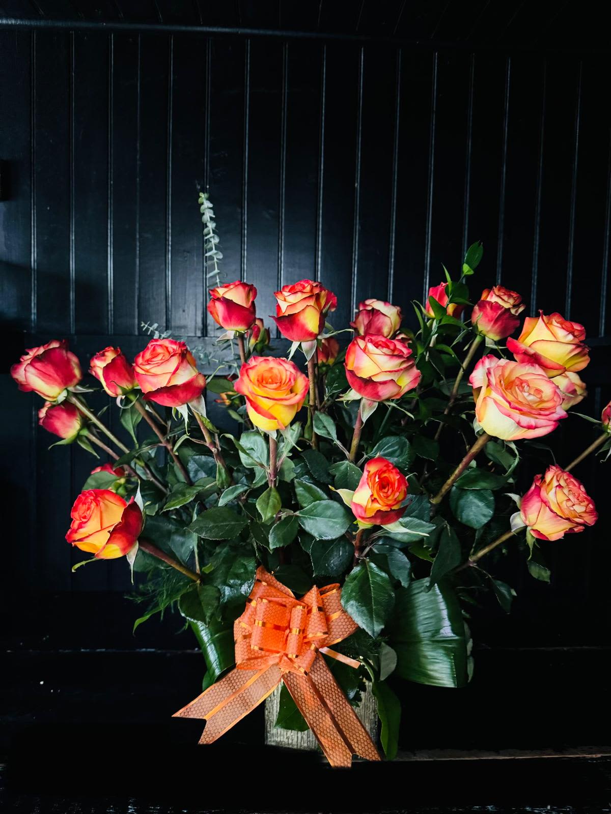 Bouquet of red and yellow roses with an orange ribbon