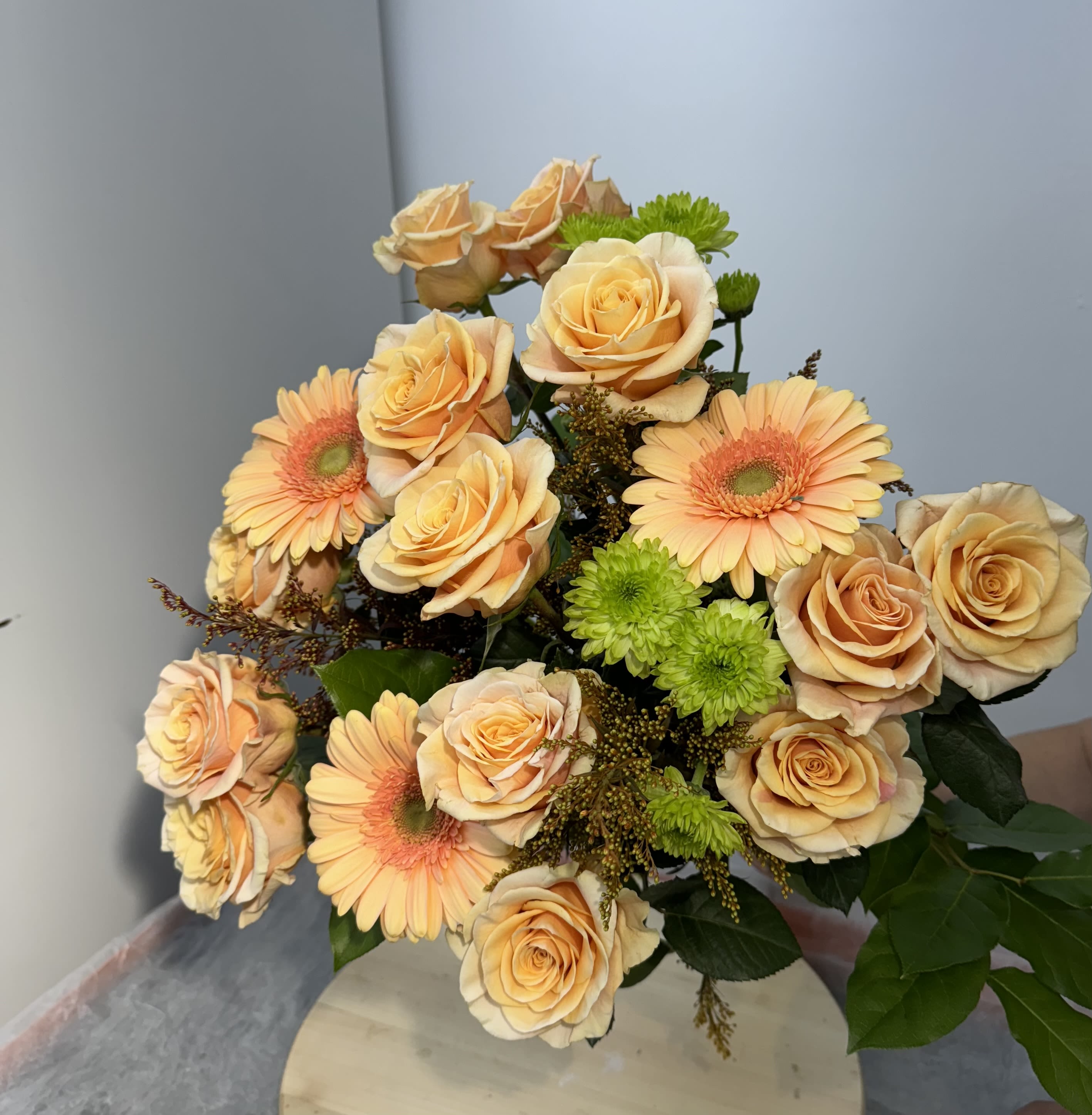 Bouquet of peach roses and peach gerbera daisies