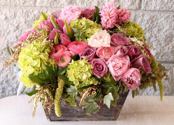 Low wooden box arrangement with pink roses, peonies, and green hydrangeas