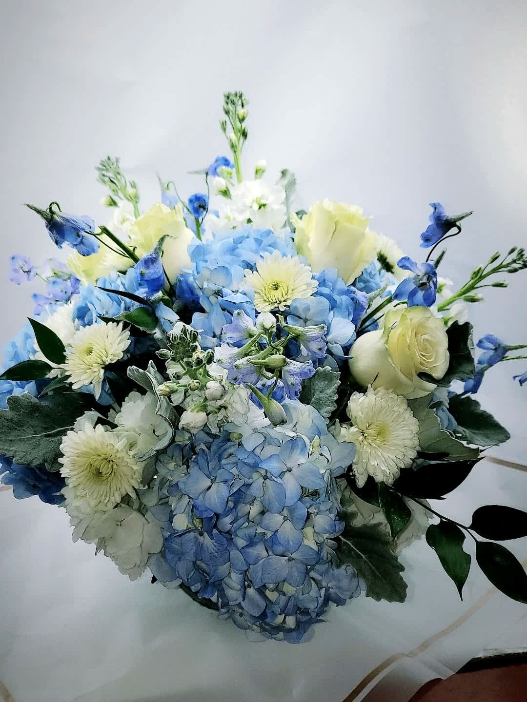 Blue hydrangea bouquet with white roses and pale daisies