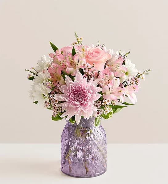 Amazing Mom Bouquet® - Soft pink roses and large pink chrysanthemums bloom together with pale pink alstroemeria and white daisy-style flowers in a rounded, feminine arrangement made for Mother's Day, birthdays, new baby celebrations, or a simple "thinking of you" gift. Lavender and purple accents weave through the pastel palette to give depth and a gentle lift-she'll feel genuinely cherished when this bouquet brightens her bedside table, desk, or favorite small surface.  *Vase may vary, depending on availability.   